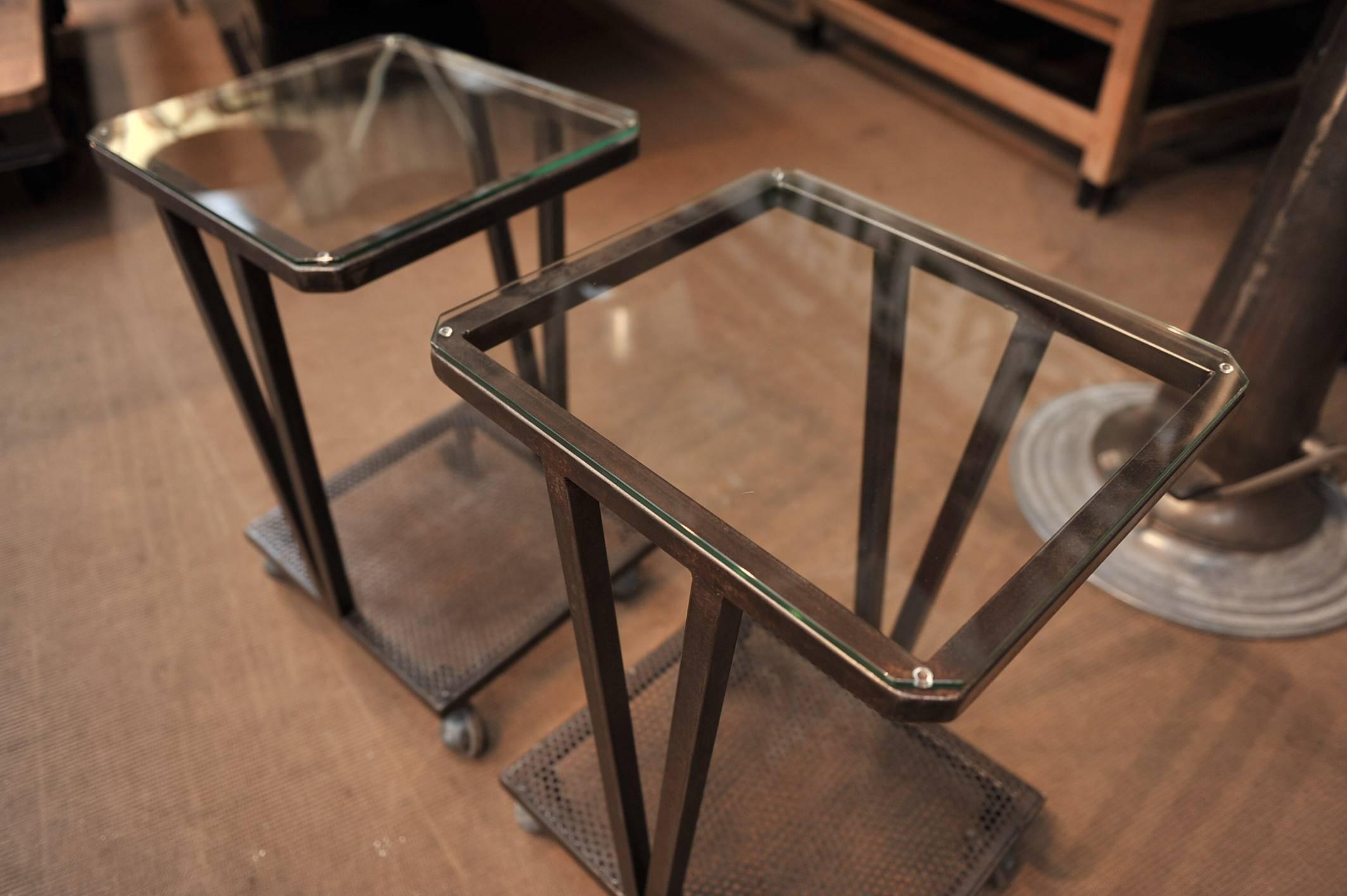 Paire of  1950 polishd iron console tables or side tables on metal turning wheels with  new tempered  glass top  6 mm .