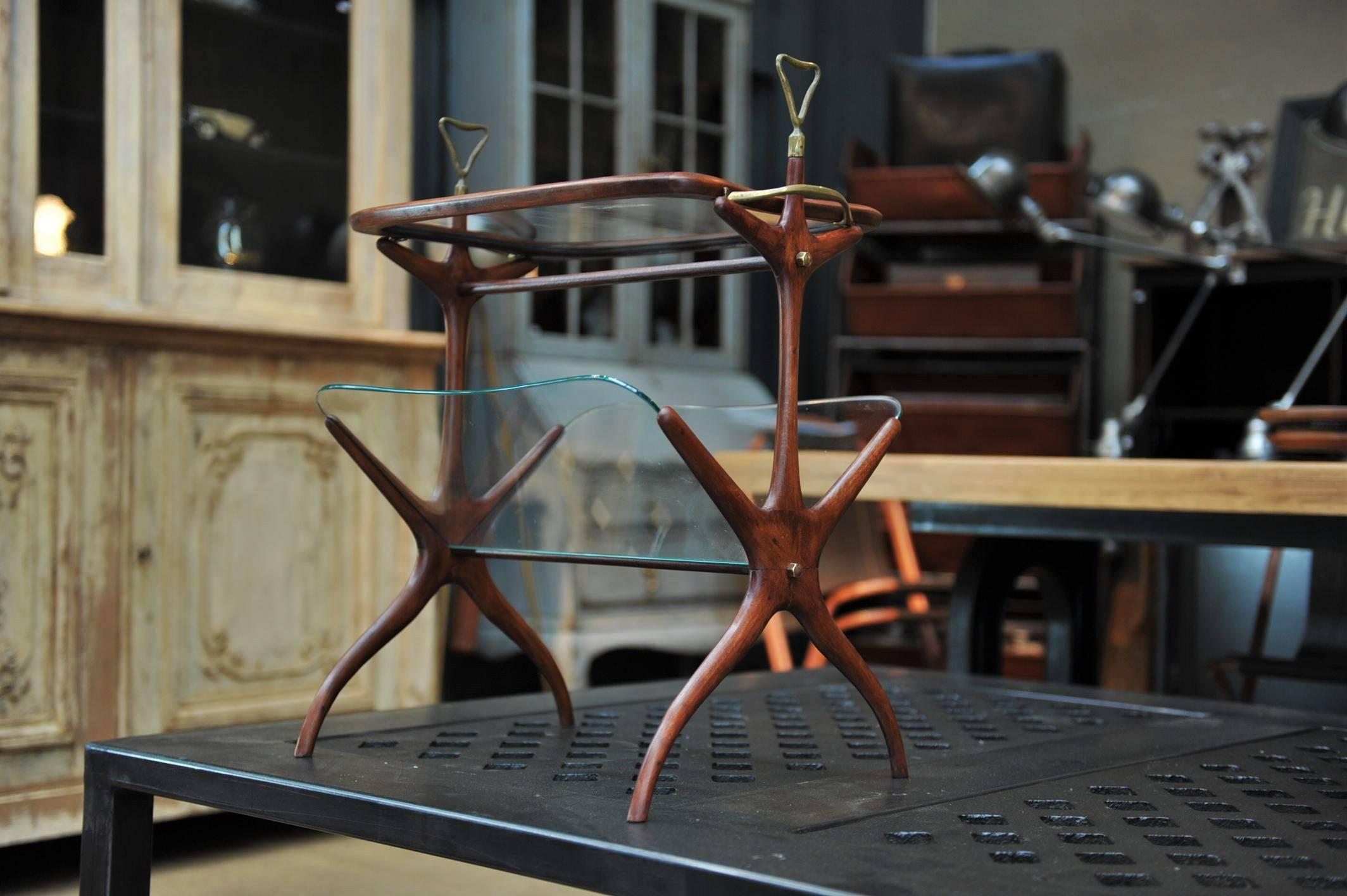 Beautiful side table by Cesare Lacca, Italy 1950s, the frame is in solid mahogany with original glass shelves on lower level for magazine rack and removable top tray to serve drinks with brass handles.



 