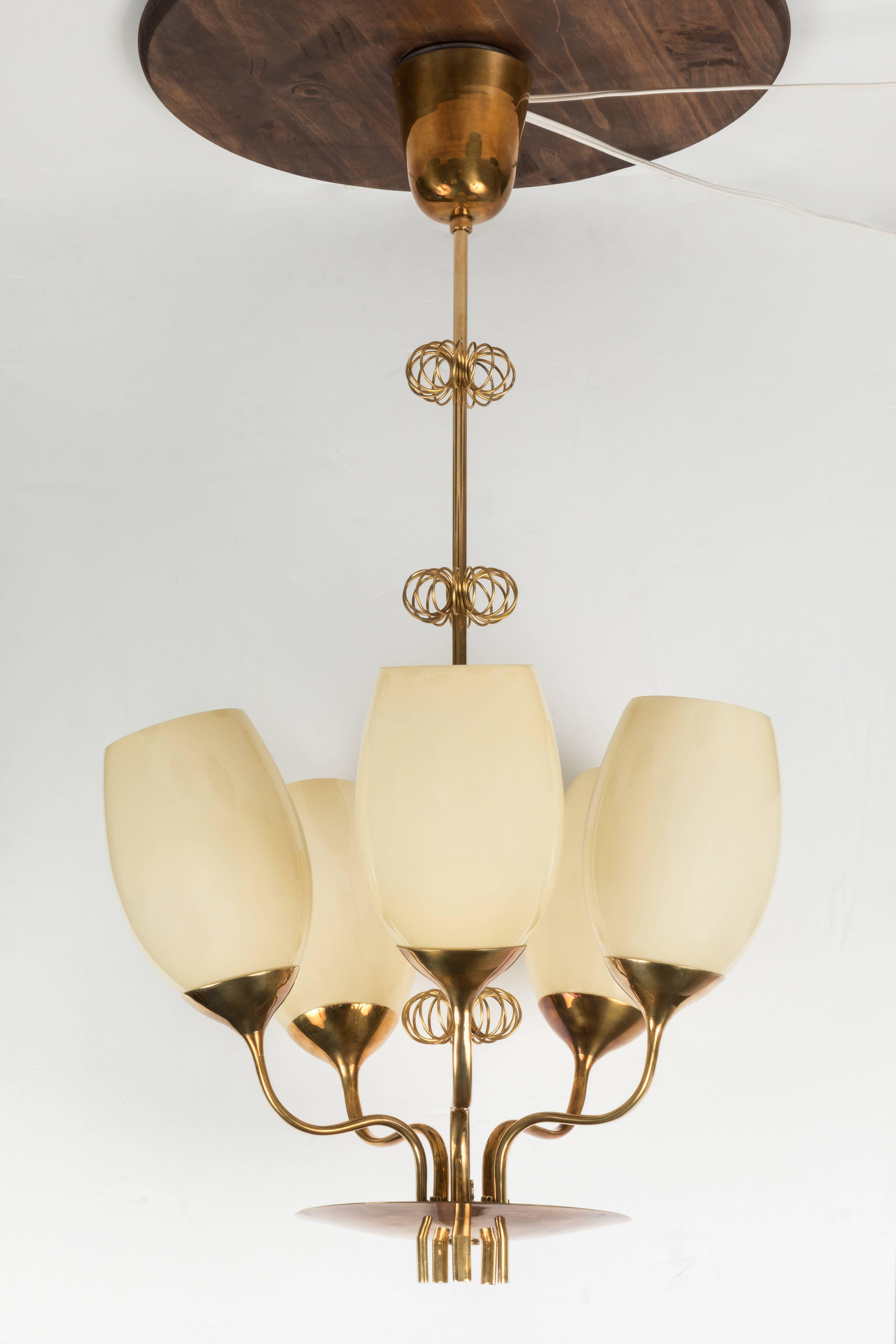 1950s Paavo Tynell Model 9029/5 Chandelier for Taito Oy. A rare and unique chandelier originally owned by a doctor from the Kuopio Children's Hospital in Finland. Executed in attractively patinated brass and handblown opaline glass and whimsically
