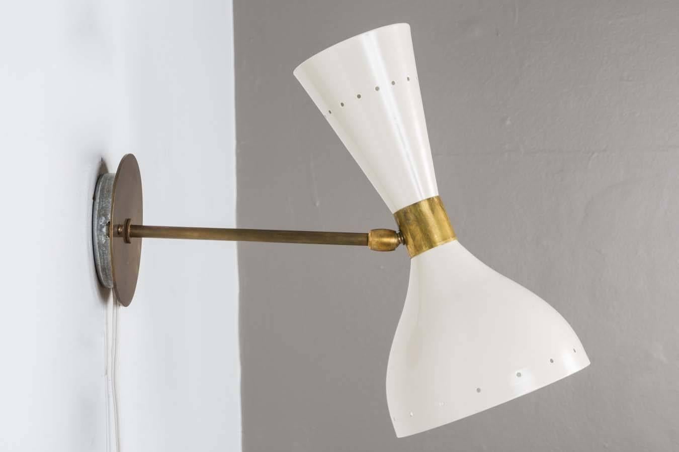 Double-cone Italian sconces in the style of Stilnovo. Adjustable ball joint where armature connects with cone. Large section of cone accommodates 75 watt standard bulb, upper smaller cone 60 watt candelabra. Executed in white enameled metal and