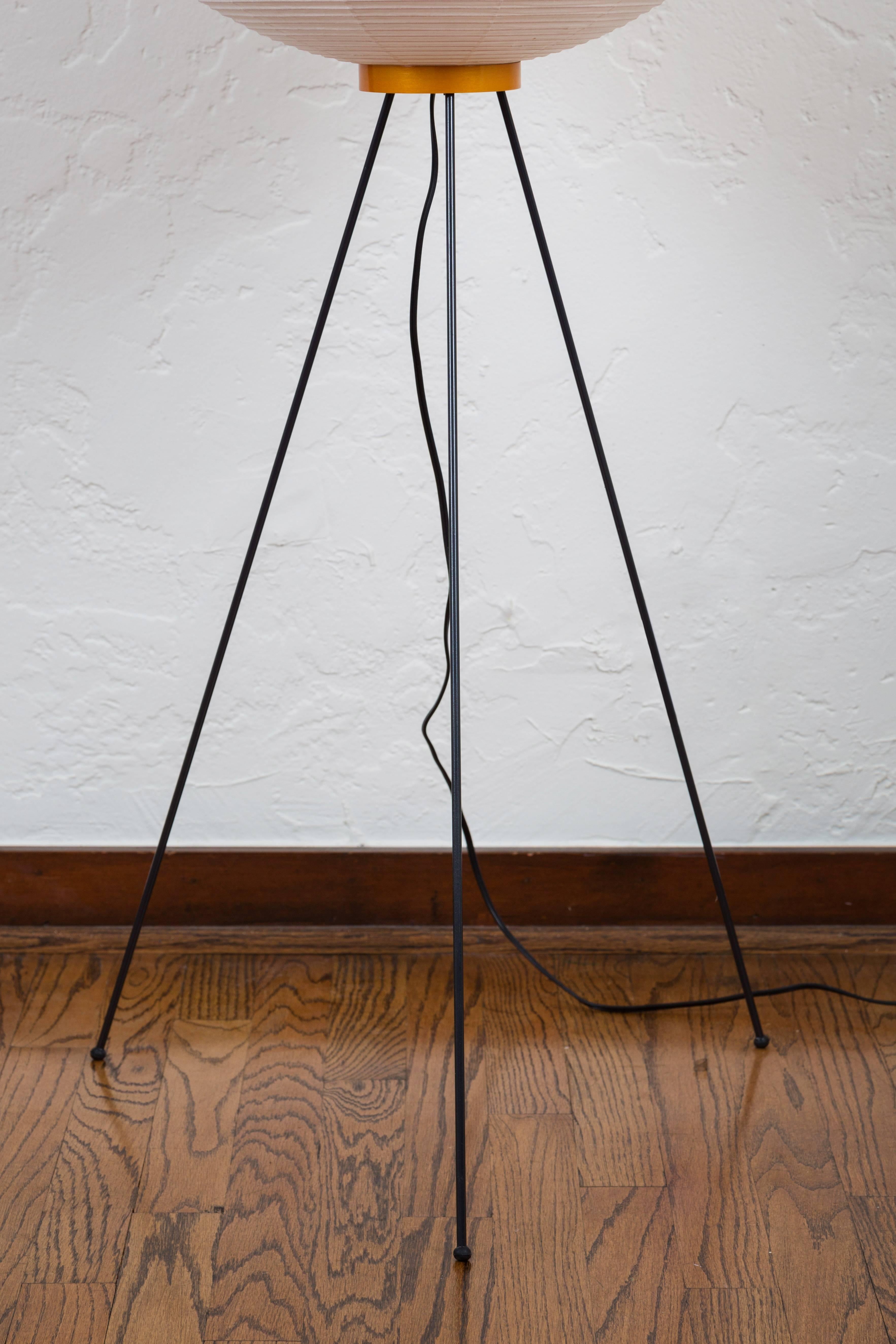 Pair of Akari 10A floor lamps by Isamu Noguchi. The shade is made from handmade washi paper and bamboo ribs with Noguchi Akari manufacturer's stamp. Akari light sculptures by Isamu Noguchi are considered icons of 1950s modern design. Designed by