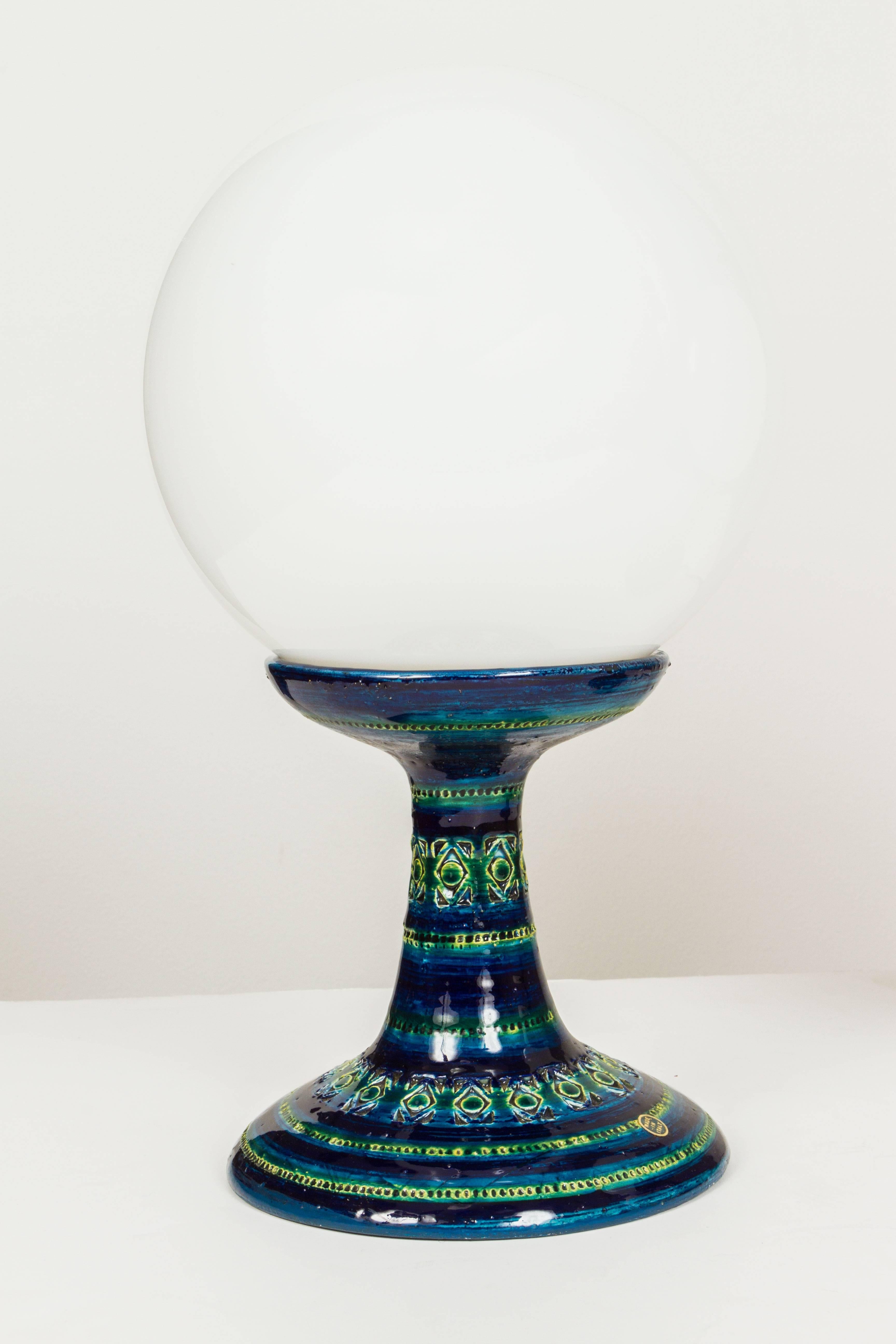 Executed in incised ceramic with blue glaze and opaline glass. Price is for both lamps.