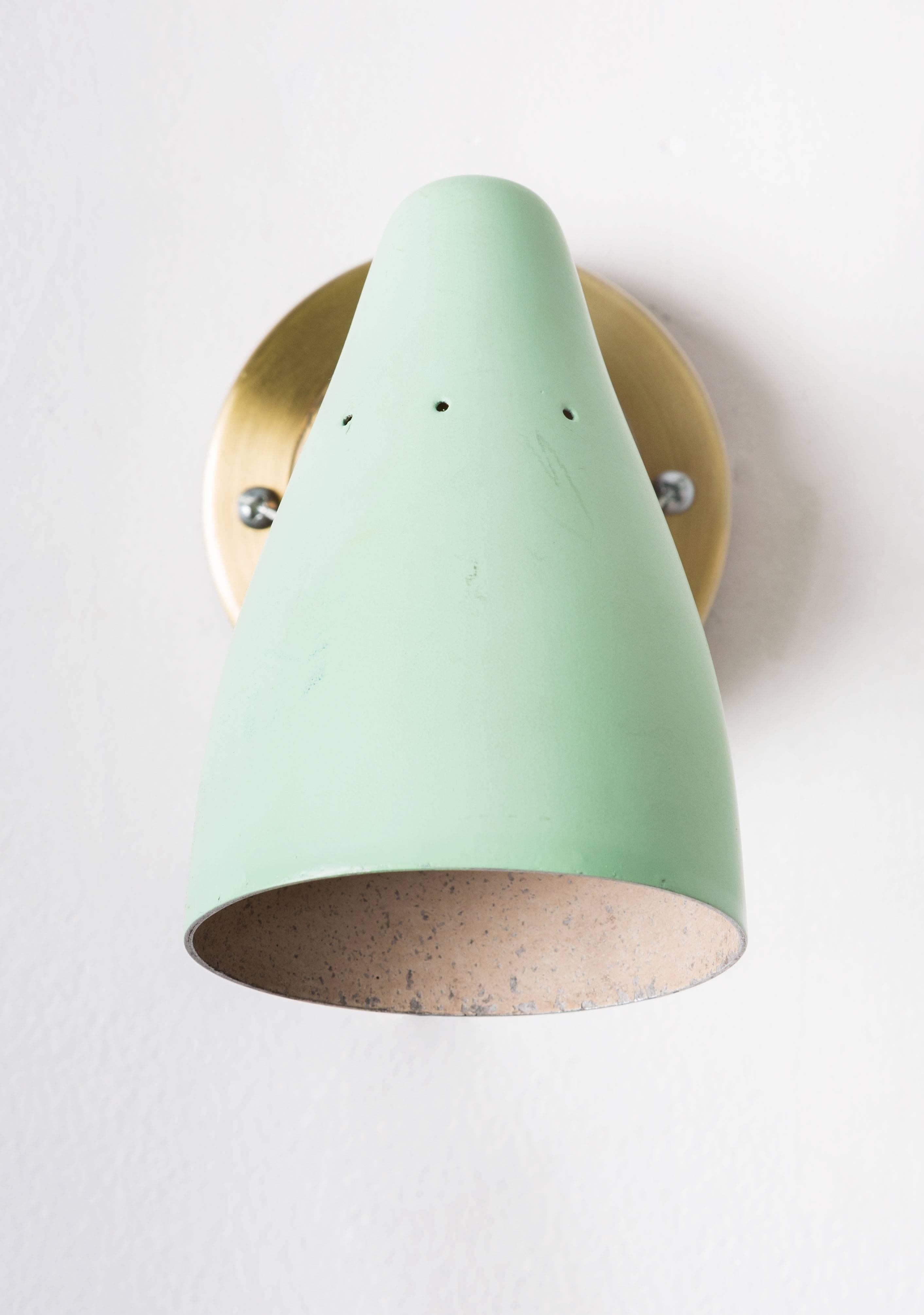 1950s Petite Italian Sconces in the manner of Giuseppe Ostuni. Executed in green enameled metal shades and patinated brass wall mounts modified for US electrical.