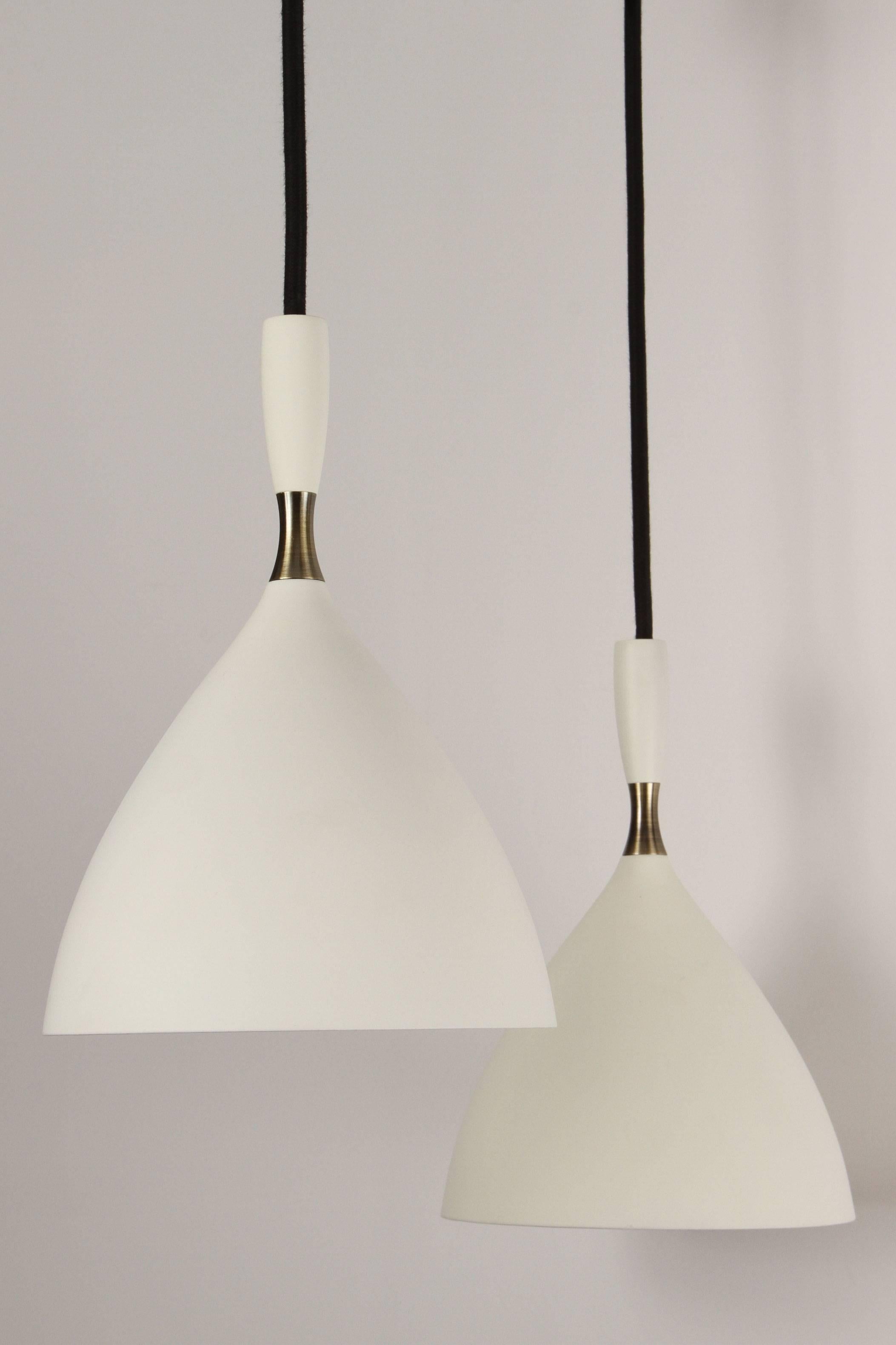 Birger Dahl pendants in the manner of Stilnovo. Architectural pendant lights designed, circa 1954 and executed in white enameled metal with exquisite brass detail. 36