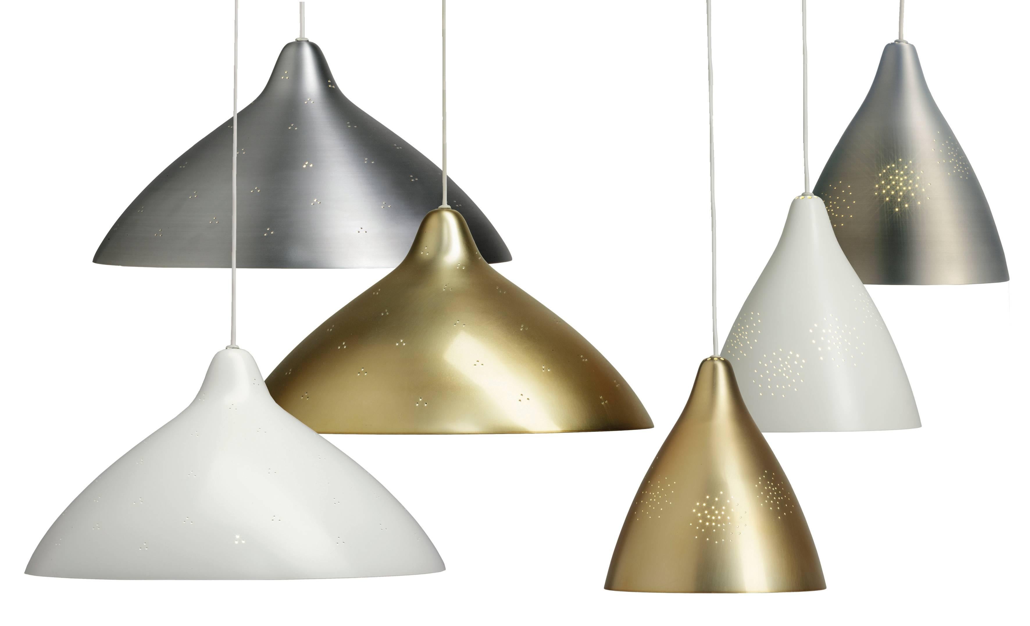 Lisa Johansson-Pape Perforated 'Hat' metal pendants. Originally designed in 1947, these authorized re-editions are true to the original charming simplicity of Pape's iconic design. The white interior of each metallic shade efficiently reflects the