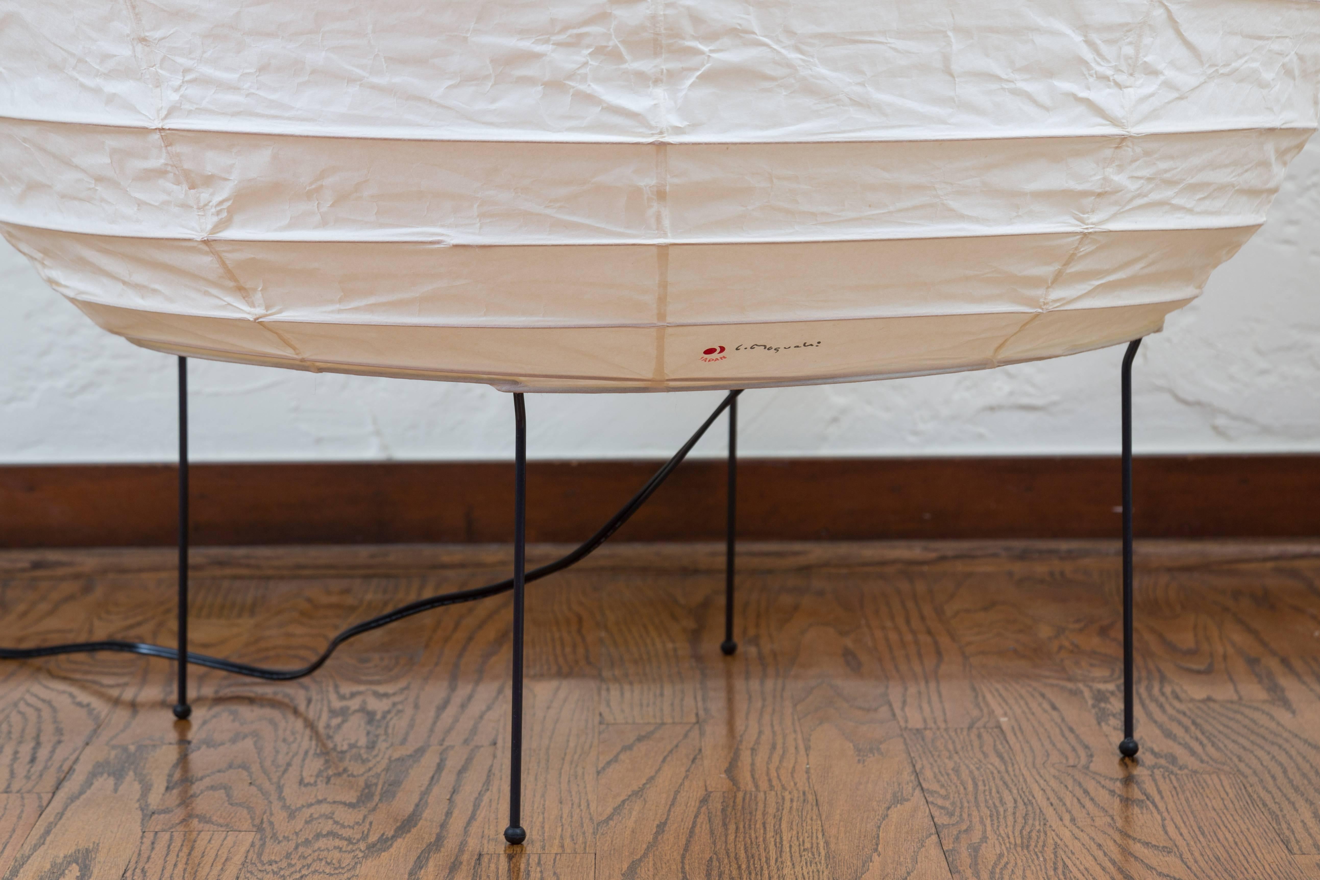 Large Isamu Noguchi Akari 23N floor lamp. Executed in handmade washi paper and bamboo ribs with Noguchi Akari manufacturer's stamp and metal legs. 

Akari light sculptures by Isamu Noguchi are considered icons of 1950s modern design. Designed by