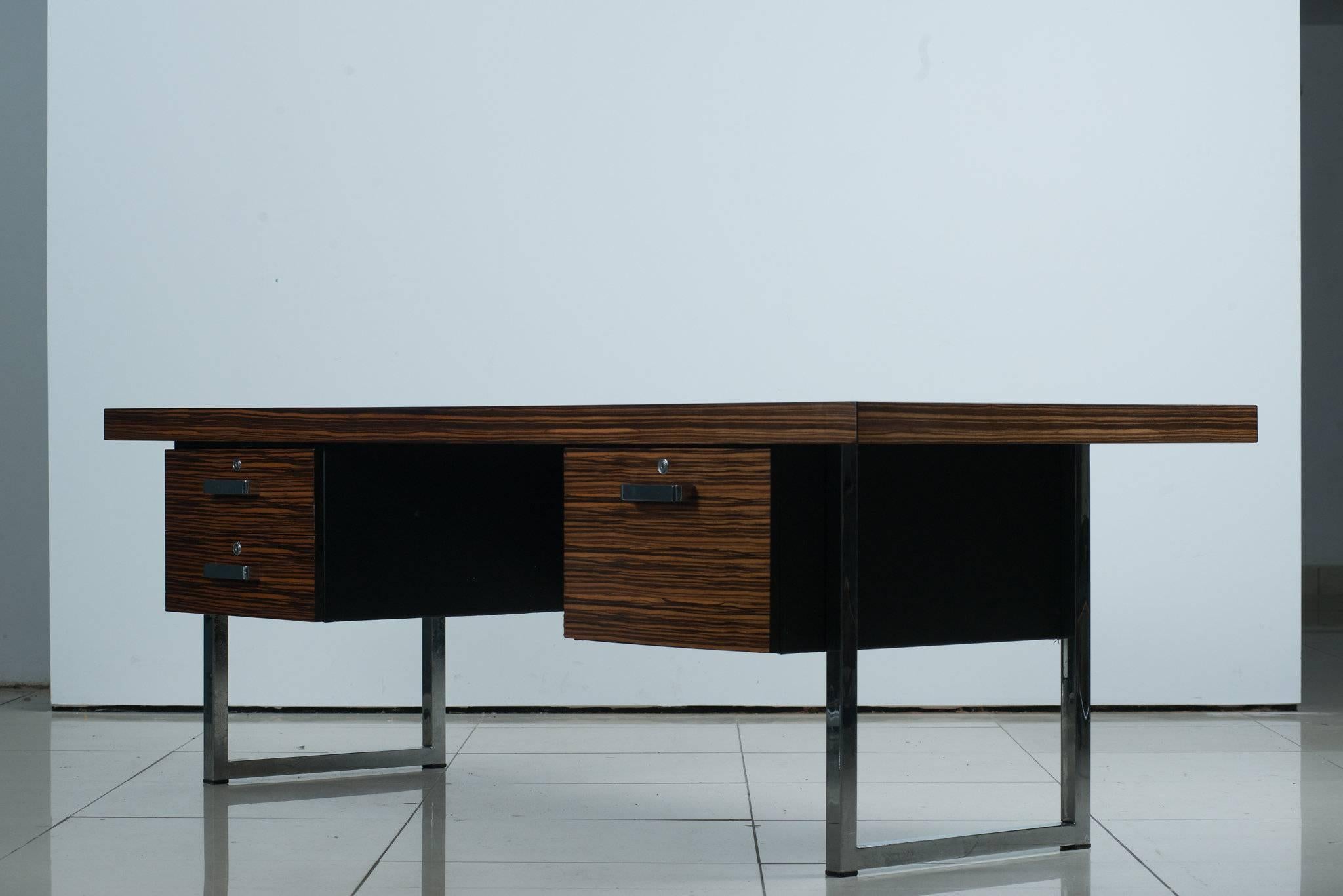 1960s rosewood executive desk by Gordon Russell Ltd. A richly appointed 1960s power desk executed in extraordinarily grained Brazilian rosewood and chrome. Solid construction and timeless lines.

Ships from London. Available to EU customers only.