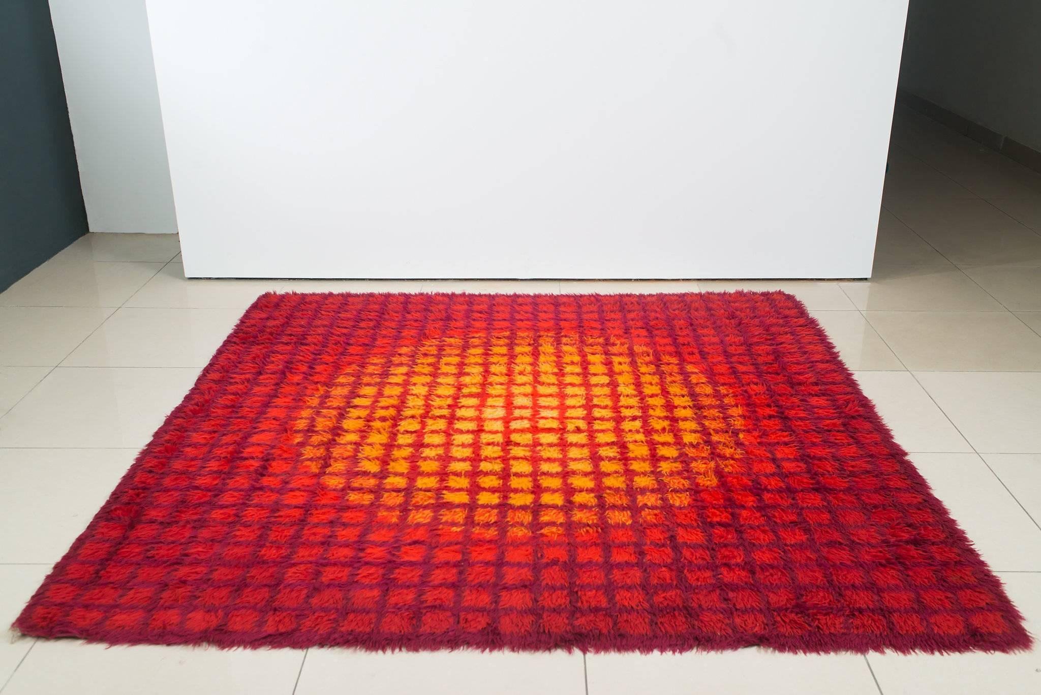 1970s geometric Scandinavian Rya rug. Executed in in orange, red yellow and bluish-purple wool. Rich texture and modern abstract lines artfully woven into the high pile. Measures 88.58 inches long x wide. In excellent vintage condition.