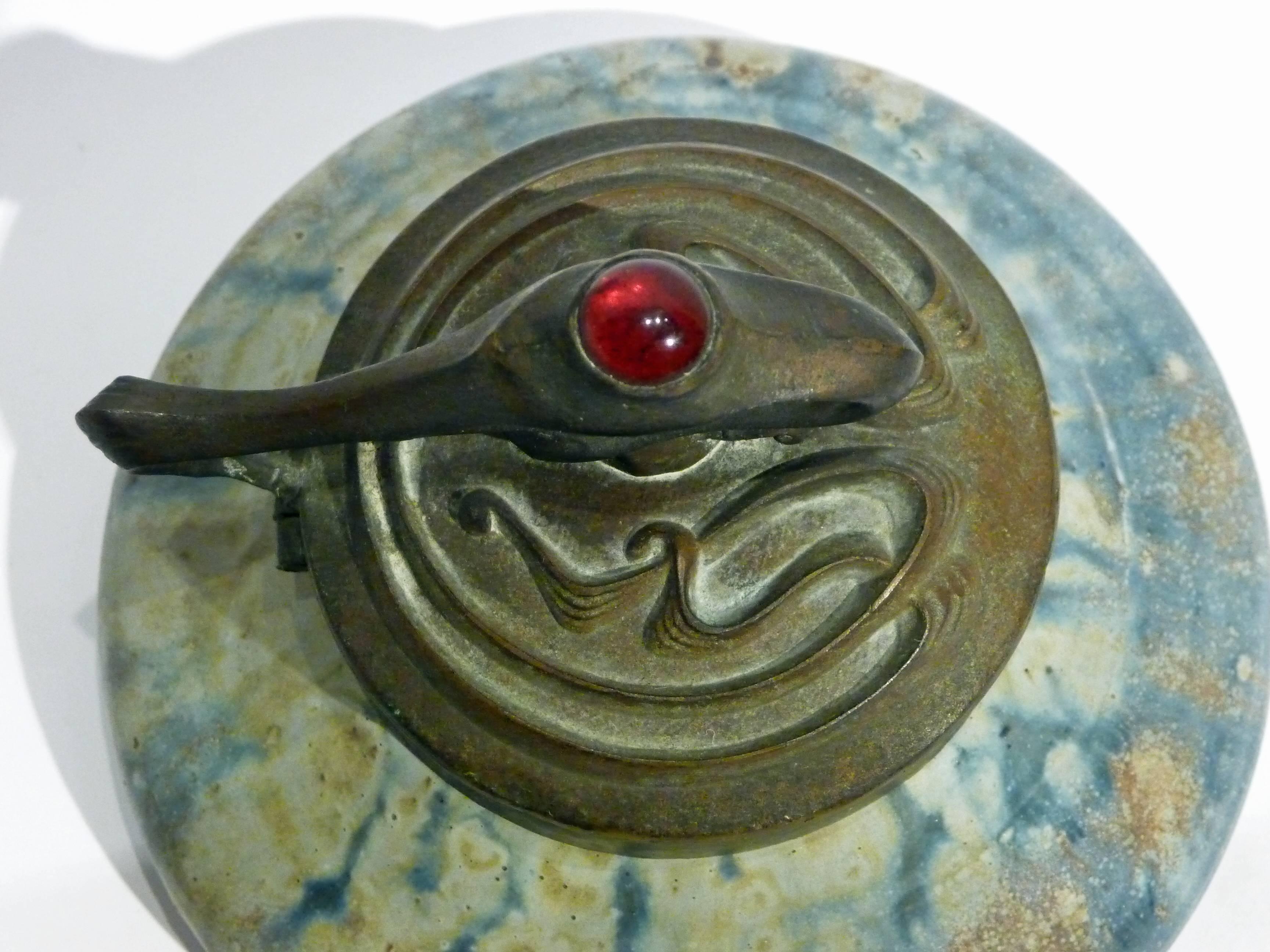 Alexandre Bigot.
An Art Nouveau earthenware inkwell with bronze mount and a red glass cabochon.
Signed underneath and bearing the inscription "D 142 CF 10 / B ° 5".
Literature: Hélène Bédague, "Alexandre Bigot, Chimiste et