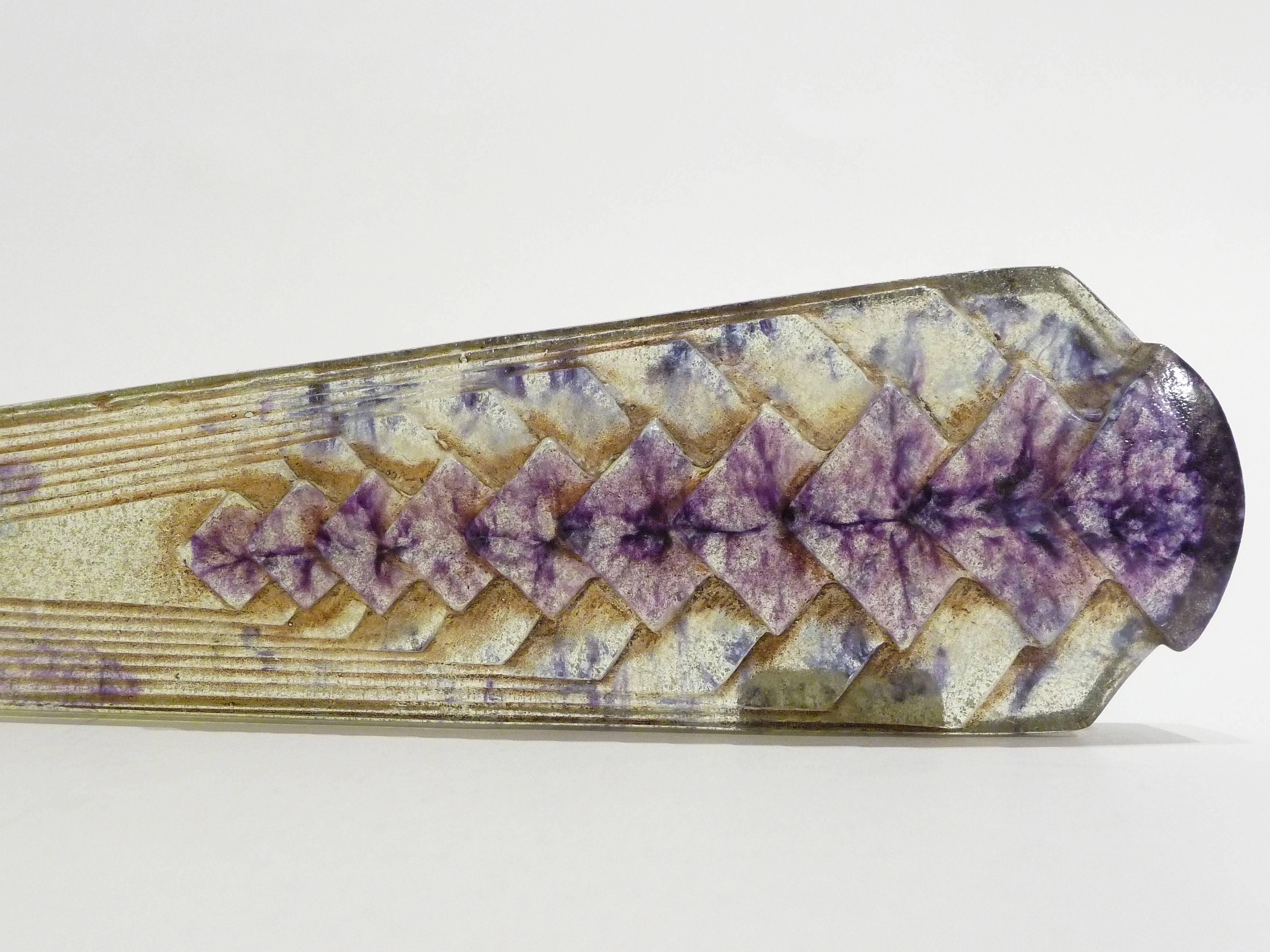 Gabriel-Argy Rousseau.
A pâte de verre letter-opener with purple inclusions and geometrical patterns in relief
signed.