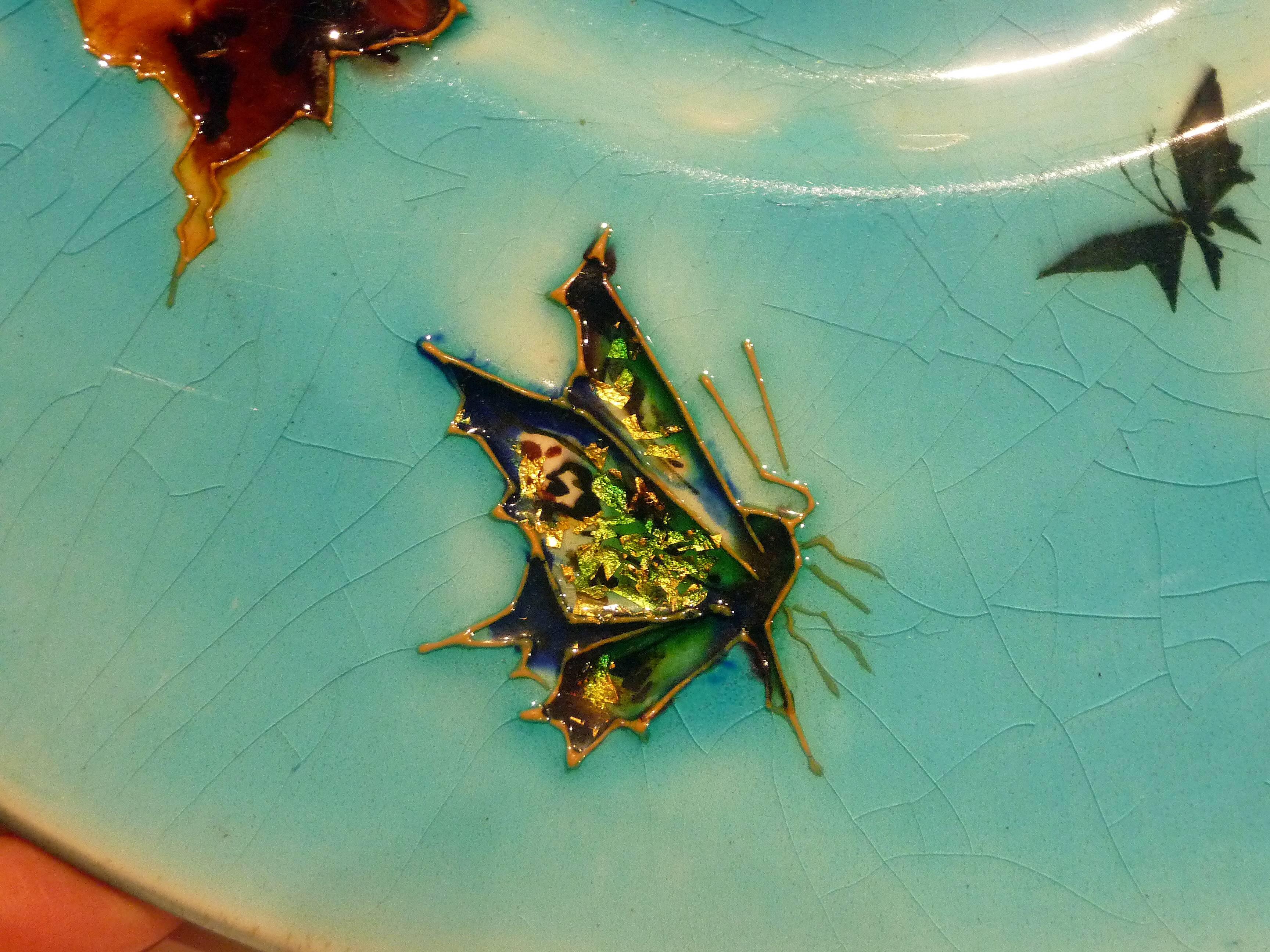 Léon Parvillée
An Art Nouveau grès plate with a cloisonné polychrome design of leaves and two butterflies, one
with gold foil inclusions.
Signed twice with the artist's monogram, also signed 
