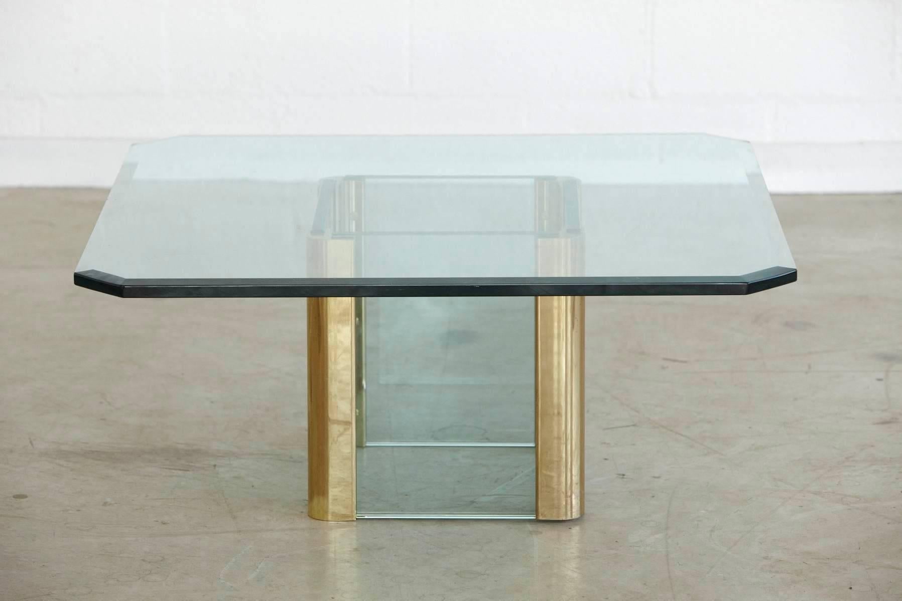 Beautiful large coffee table with a square (octagonal) beveled 3/4 inch thick glass top mounted on a base comprised of four 3/4 inch glass panels encased in rounded brass elements. 
Designed by Leon Rosen for Pace in the 1970s.
Dimensions: Base is W