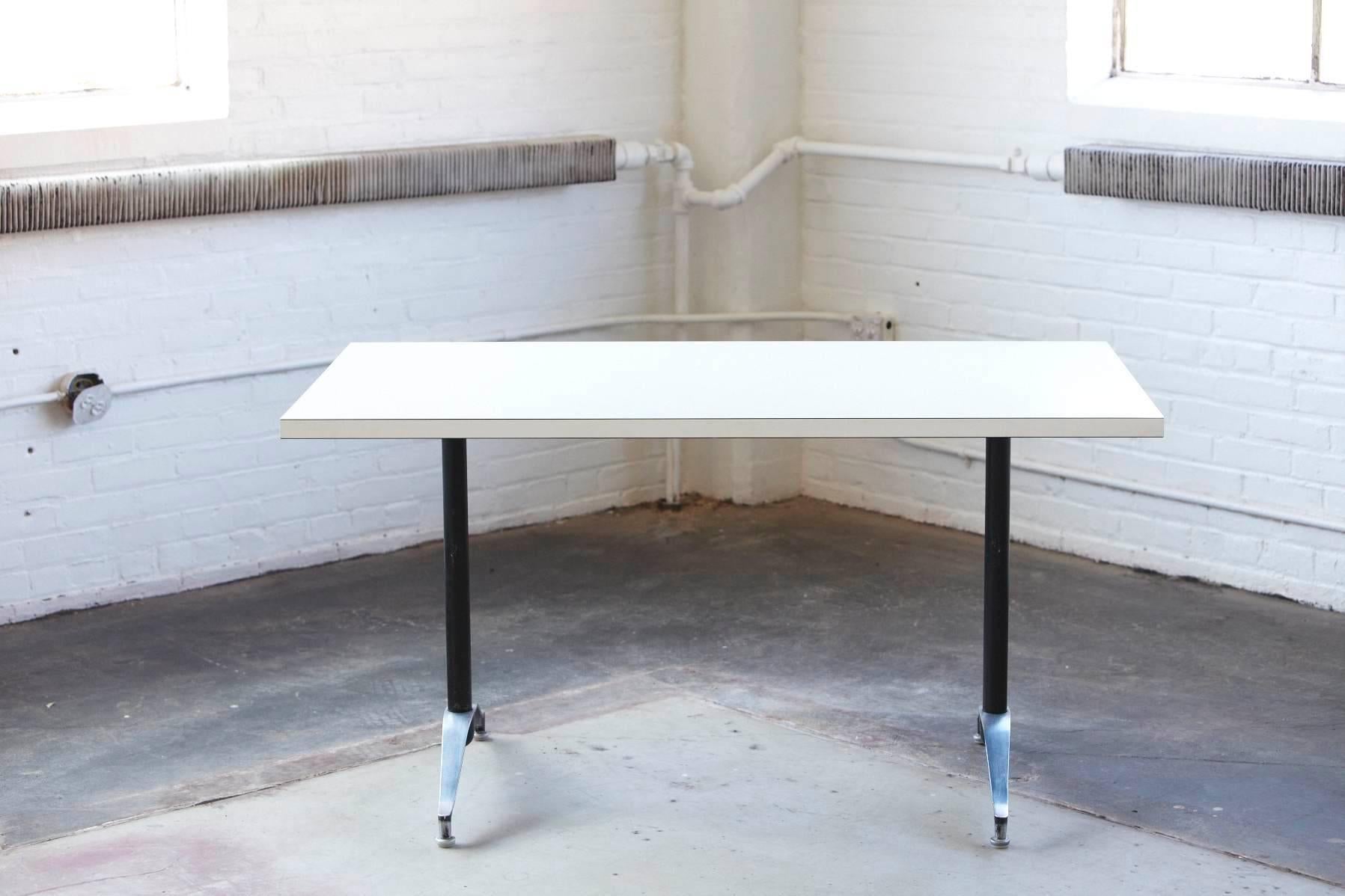 Minimalist dining or work table with white laminate top and black aluminum frame with polished aluminum legs. Great table for smaller spaces or studios in excellent condition, by Eames for Herman Miller.