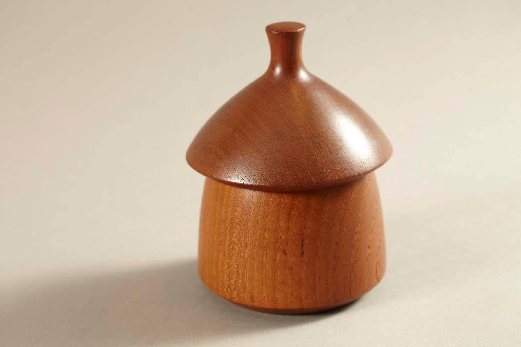 Sculptural lidded teak vessel by Jens Quistgaard for Dansk Designs Denmark IHQ. Early design, shows the Four Ducks mark on the bottom.
Very nice acorn form with beautiful grain and patina. One small and shallow chip to one side of the top of the