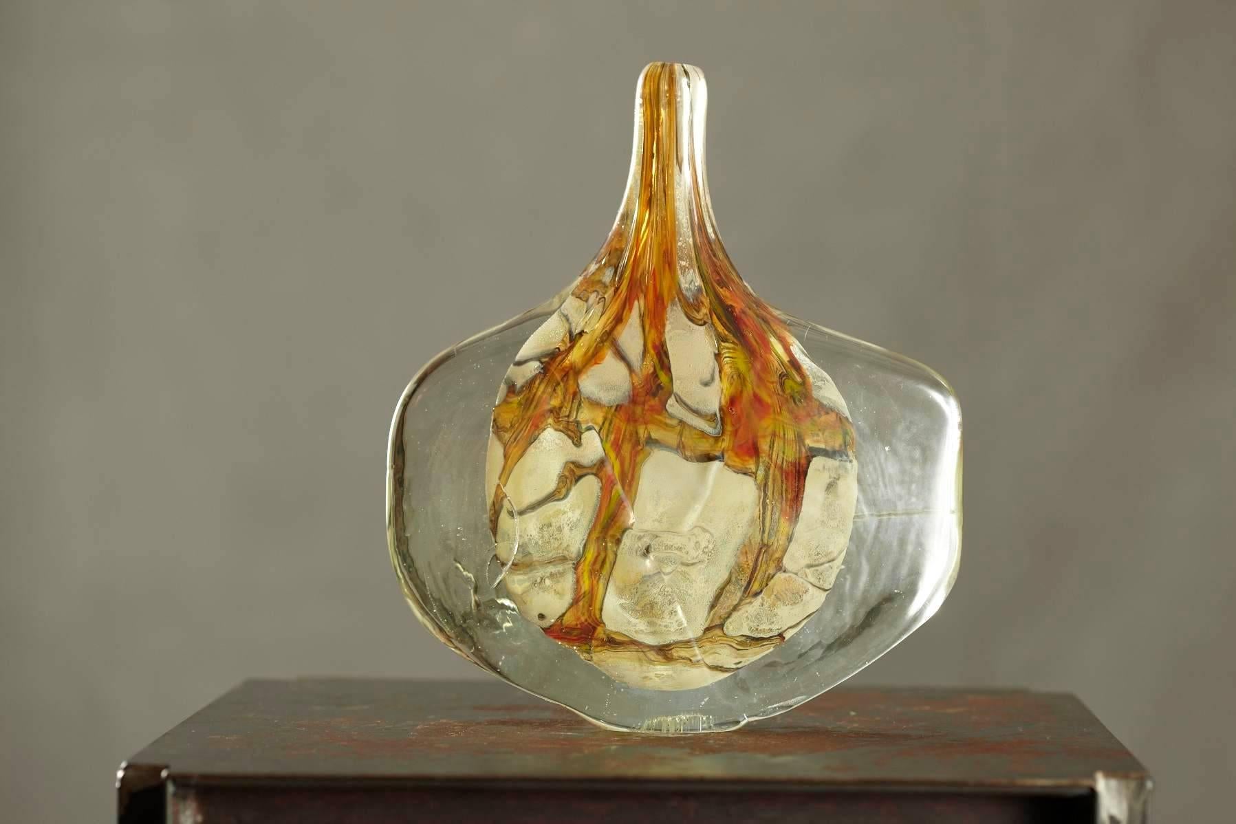 Beautiful free-form handcrafted, blown art glass vase in warm tones of green, beige, brown by Michael Harris for Mdina Glass, Malta.

Michael Harris (1933-1994), was an English glassworker.
With his wife Elizabeth, he set up Mdina glass on the