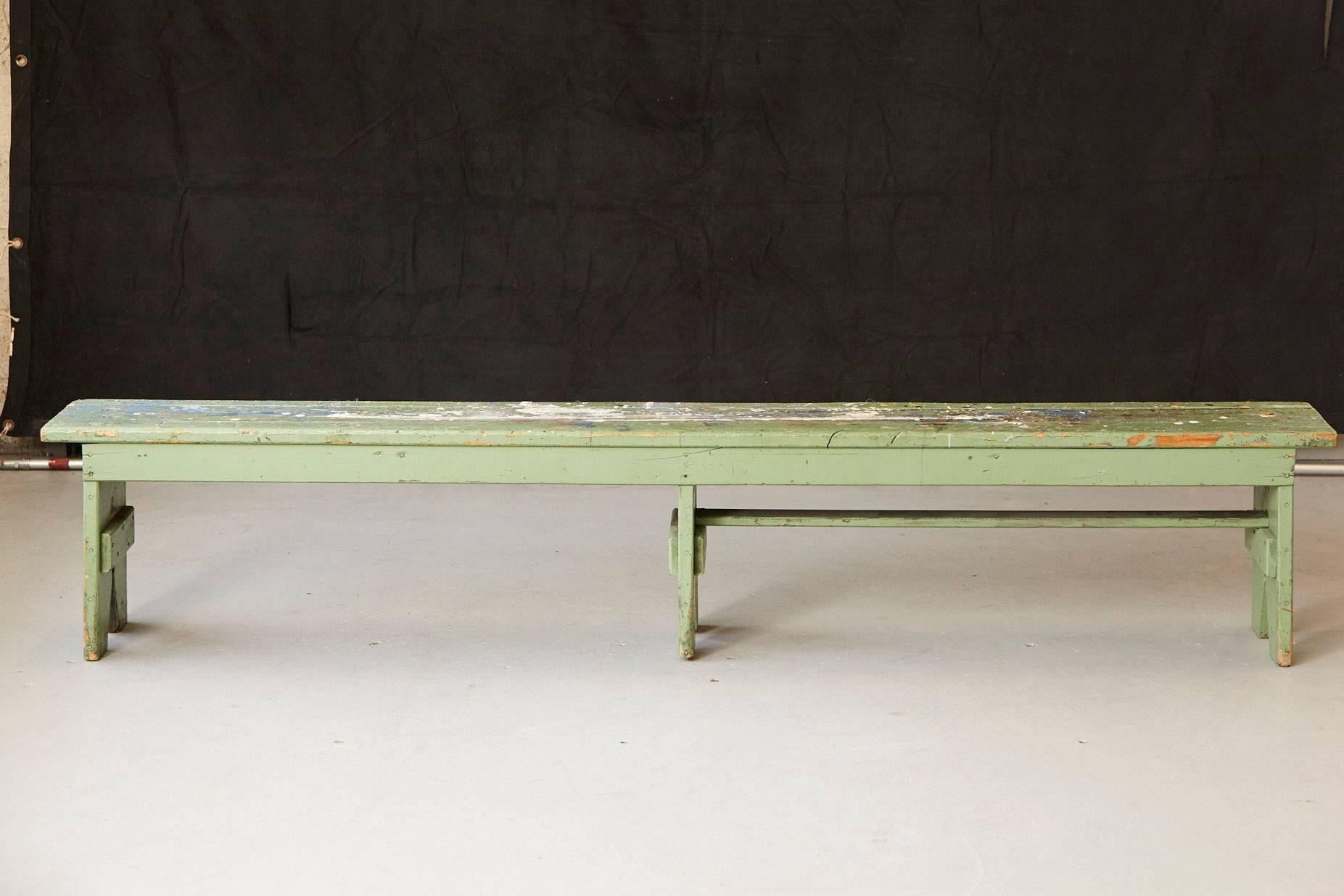 Very unique and colorful primitive green painted pine bench with lots of color splashes from an artist's atelier. The long bench has been used as an 'easel' for large format paintings. 
Very nice patina, some losses to the wood, please refer to the