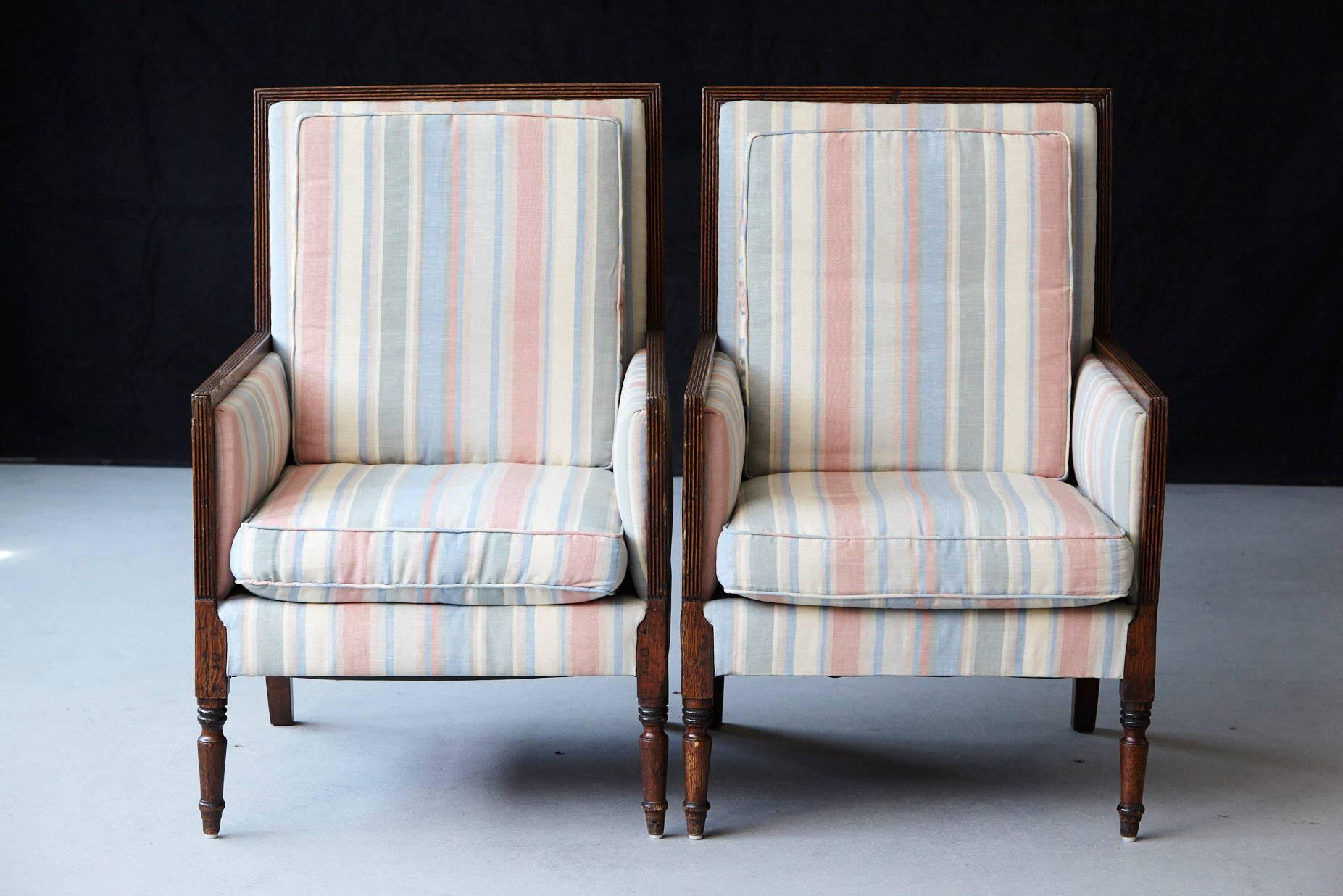 Beautiful pair of Italian neoclassical style bergères with a reeded frame raised on turned cylindrical legs.
The rectangular backs and seats with loose cushions covered in pastel tone striped moiré taffeta.
There are some minor, hardly visible spots