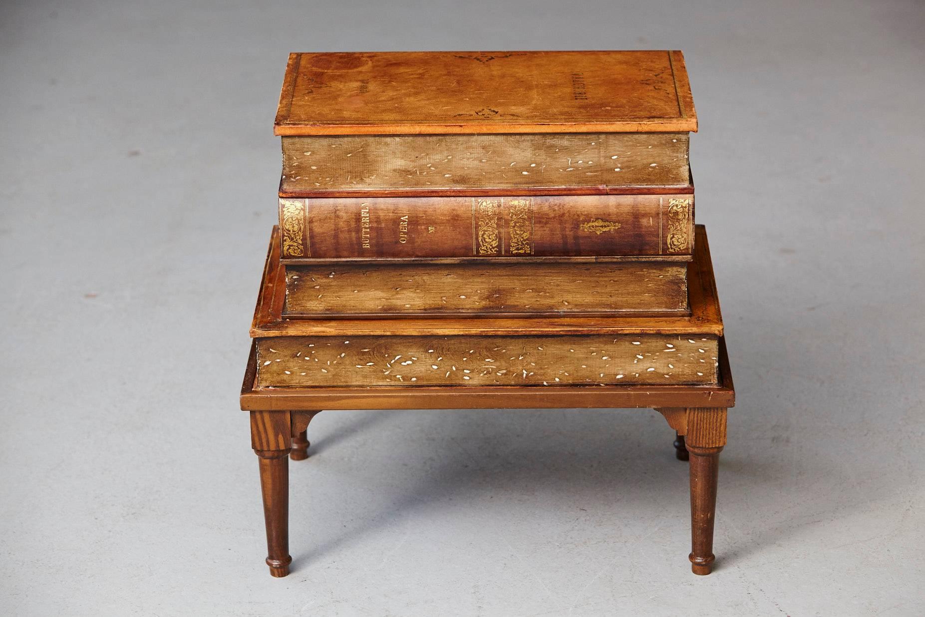 Four graduate oversize faux leather volumes with gilt tooling raised on a wood table base.
Hinged top revealing a deep well. Made in Italy.