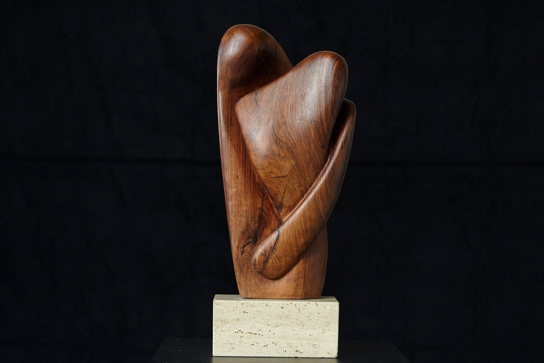 Gorgeous, unique, biomorph abstract teak sculpture on travertine base showing a pair of lovers in a close embracement, like melting into one person.
Sculpted by hand from a solid piece of teak. Artist unknown.
Fantastic touch and beautiful age