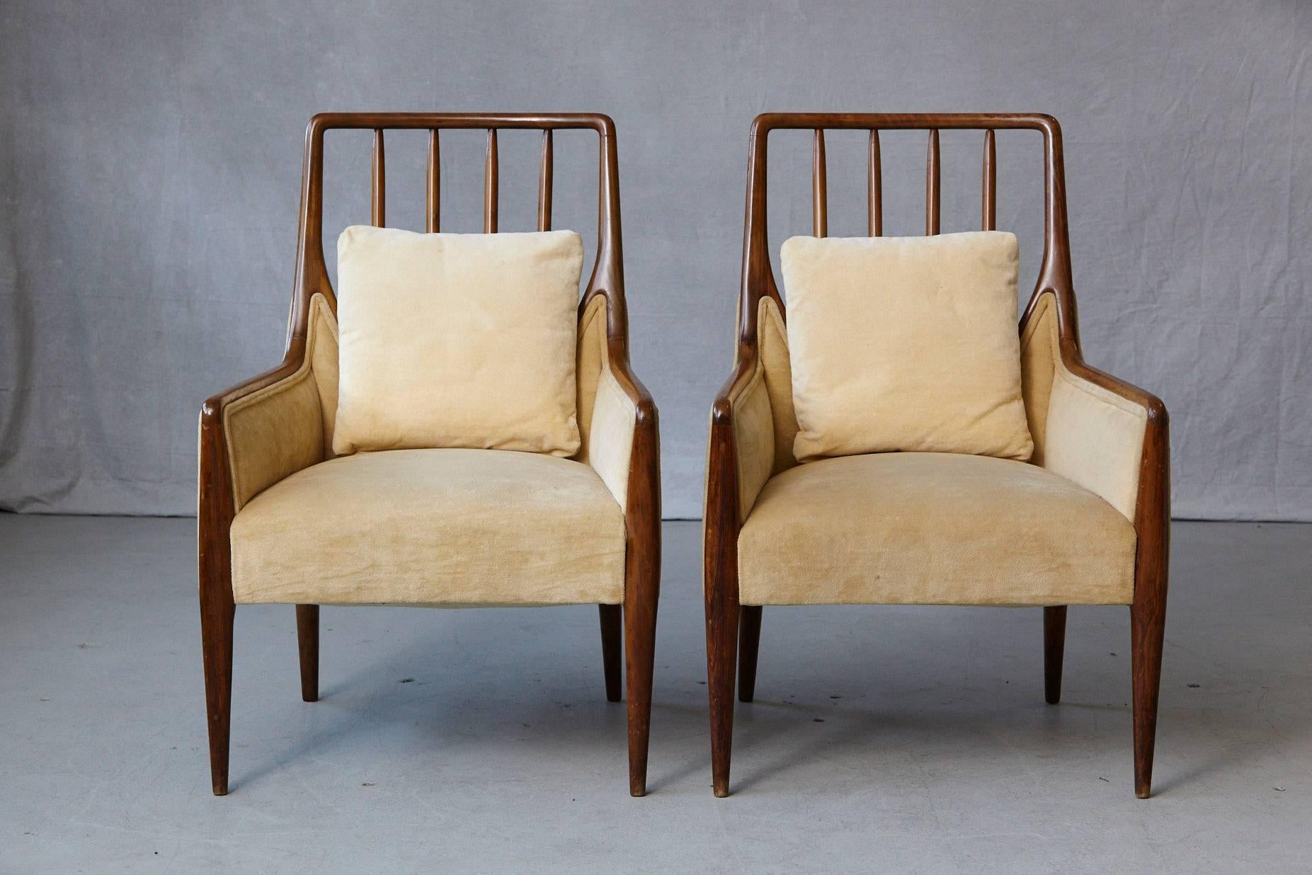 Exceptional pair of high back walnut lounge chairs in the style of T.H. Robsjohn-Gibbings in gold beige velvet fabric with matching pillows in original condition.
There are some scuffs to the legs and back, please refer to the detailed photos.