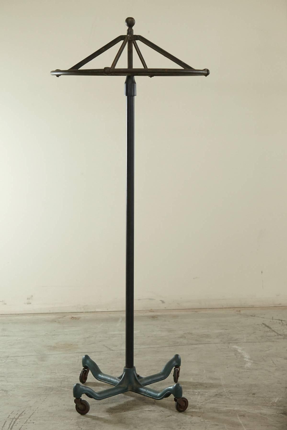 Vintage round top Industrial coat rack on casters. The casters move smoothly, the rounder spins easily. A sturdy, well balanced cast iron and steel pipe rack, in a beautiful minimal design. The rack comes in three pieces.