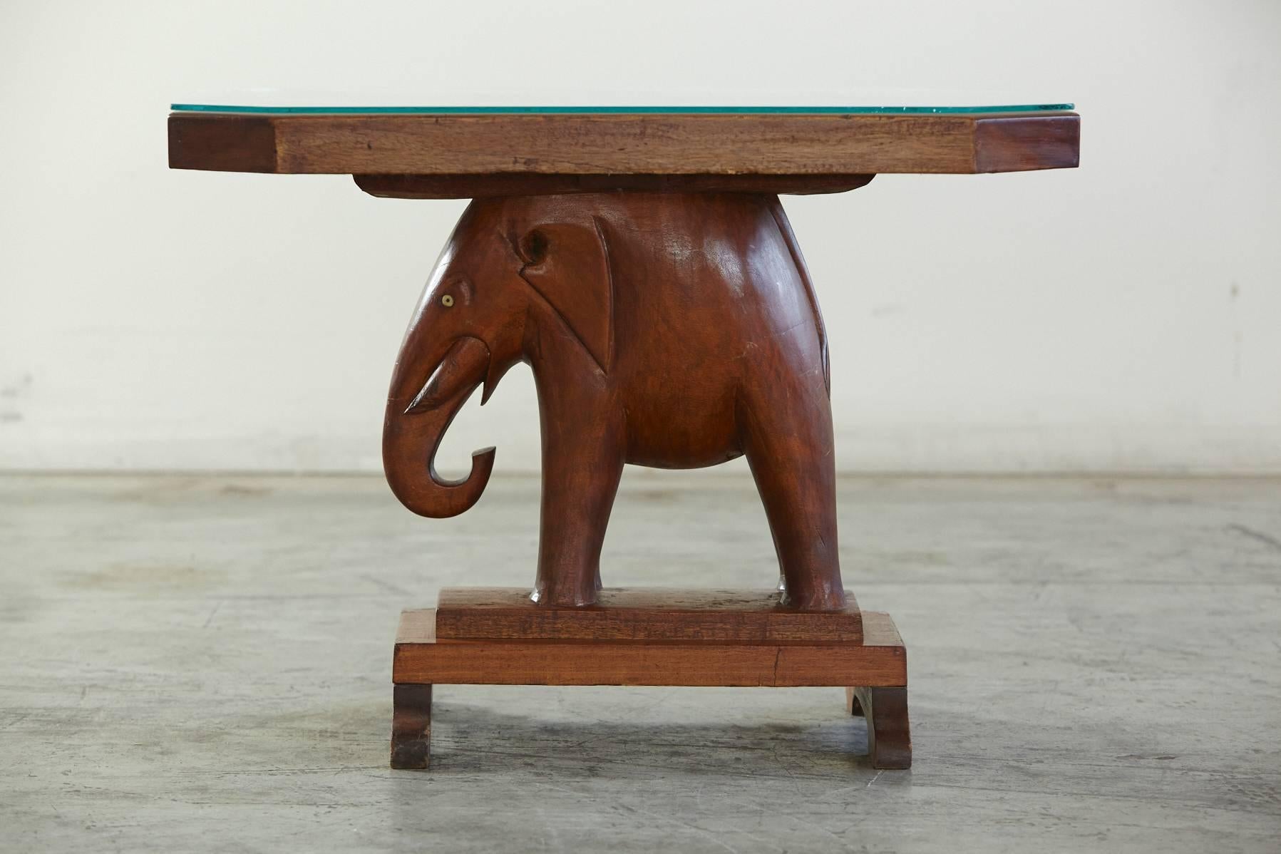 Octagonal mahogany end table with a carved elephant figurine base, with eyes made of bone, Nigeria circa 1940s. 

A similar, oval table was given to Mrs Roosevelt and presents almost the identical base and carvings, as the one which was owned by