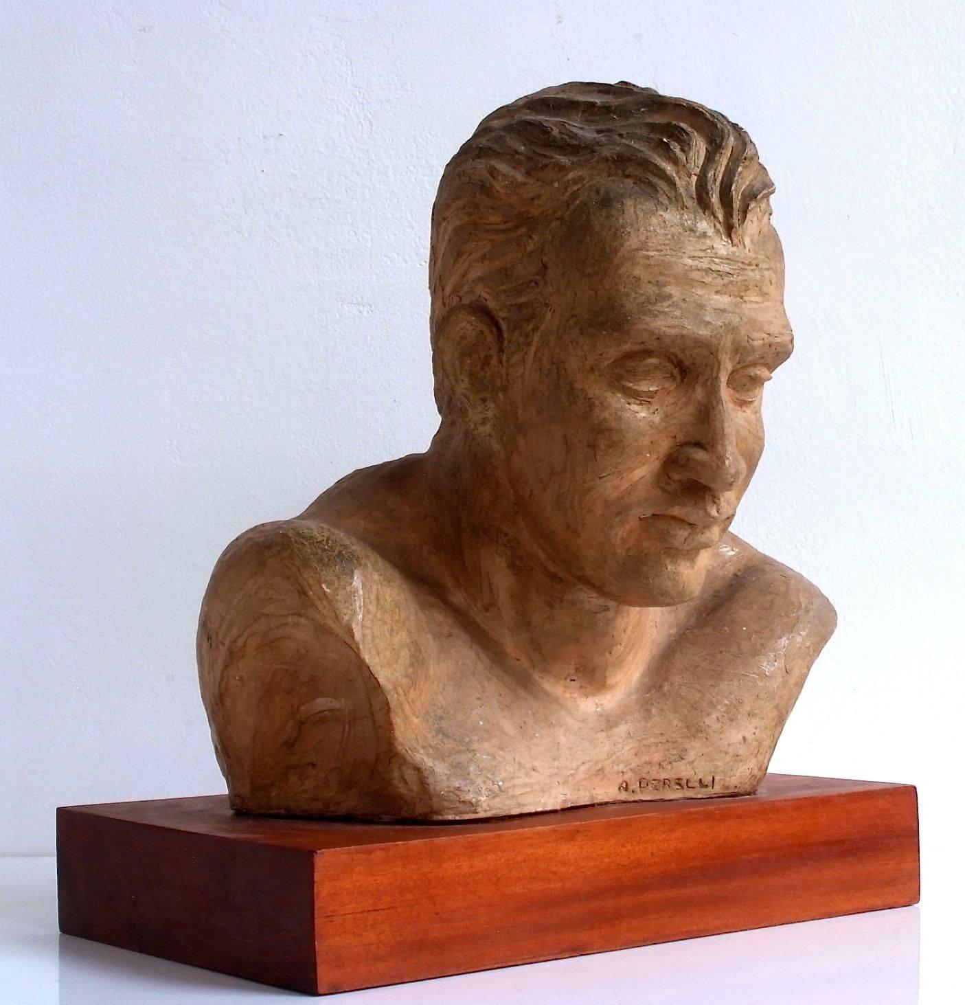 Intricate 1950s clay bust of an athlete signed by A. Perelli mounted a wood base. The work is in very good condition from all sides, nice patina.
Base: W 11.5 in x D 7 in x H in. Sculpture 10.5 in x D 9.5 in x H 10.75 in.