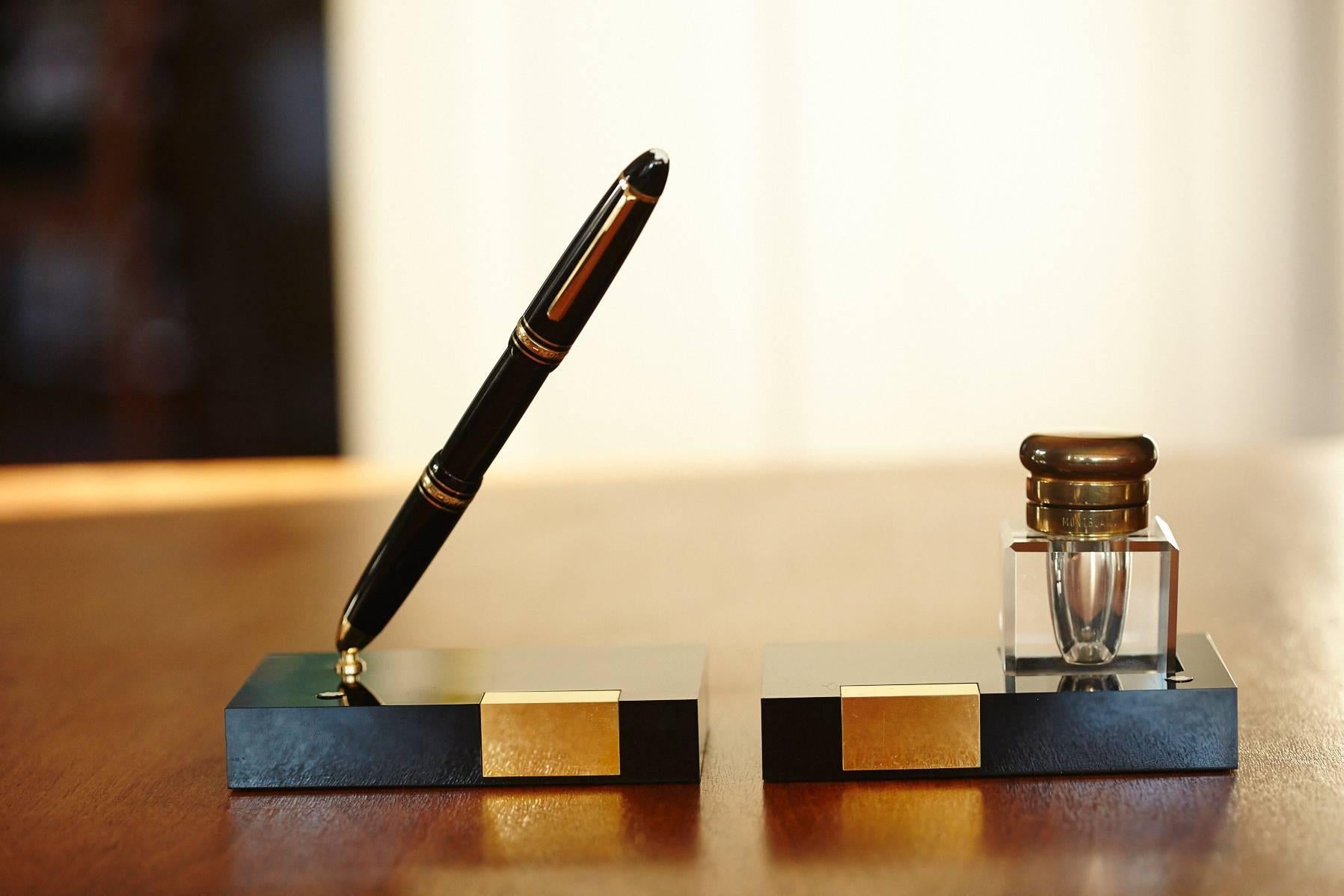 Très chic, never used Montblanc writing set, composed of a fountain pen holder and a leaded crystal inkwell with a heavy brass lid on a shiny black resin base,
circa 1960s.
The Montblanc fountain pen 