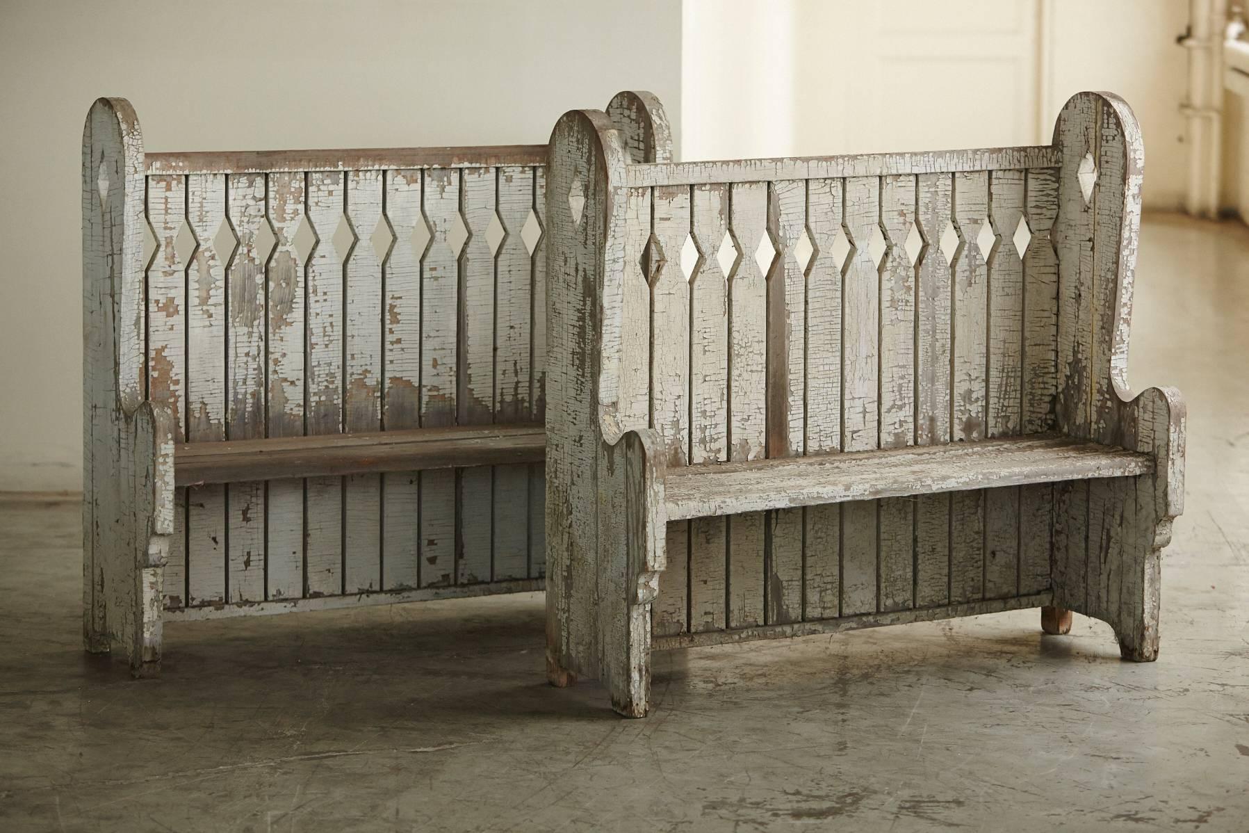 Rare pair of matching oak high back settle benches from the late 19th century.
Original paint, beautifully weathered with oxidized patina and a nice craquelure.
Graphic and puristic cut-out pattern in the back.
 