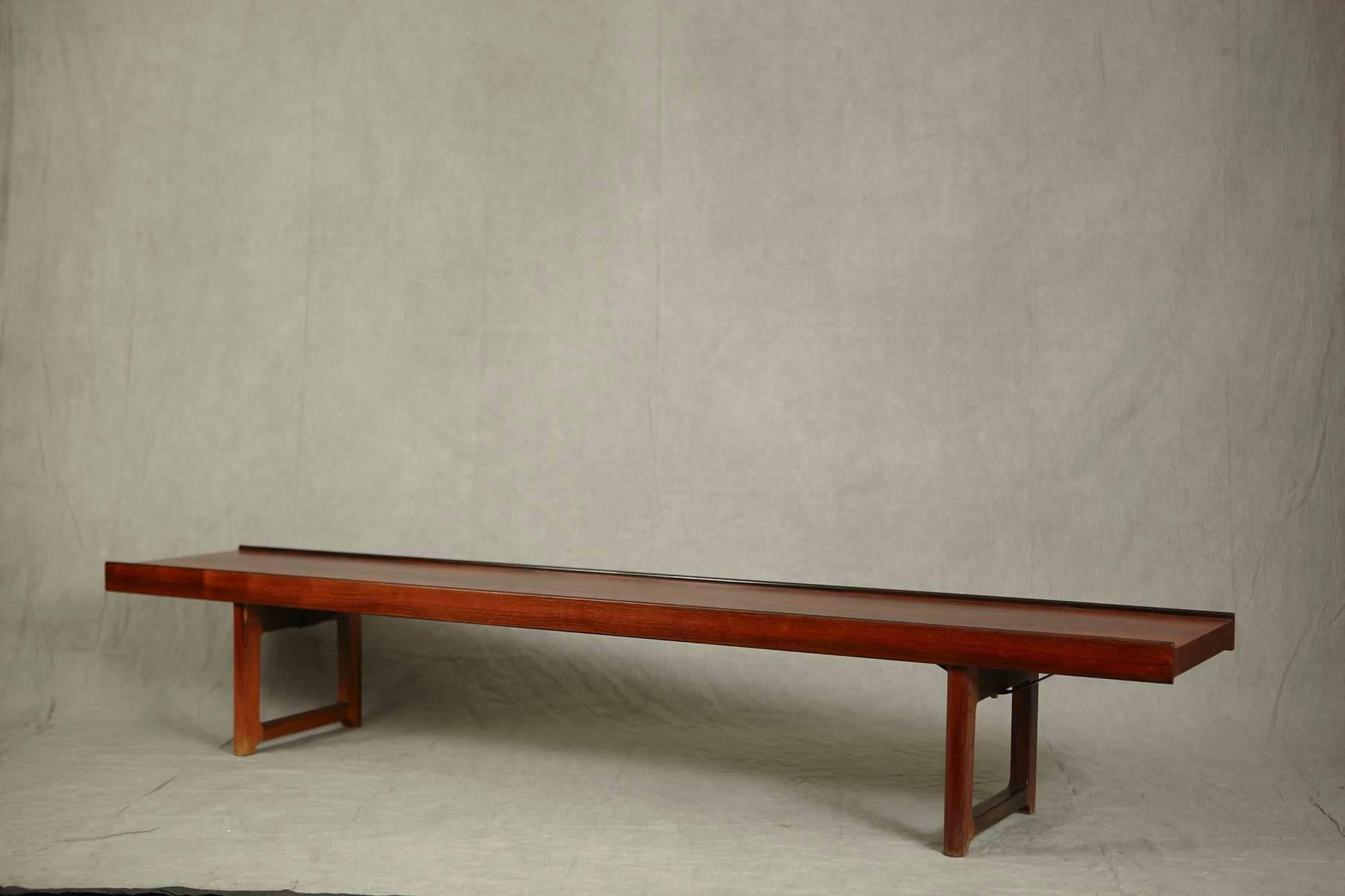 Versatile Scandinavian Modern rosewood bench or table titled 'Korbo', designed by Torbjørn Agdal for design company Bruksbo and manufactured by Mellemstrands Trevareindustri SA, all Norway, circa 1960s.
Very minimalist style with lipped sides and