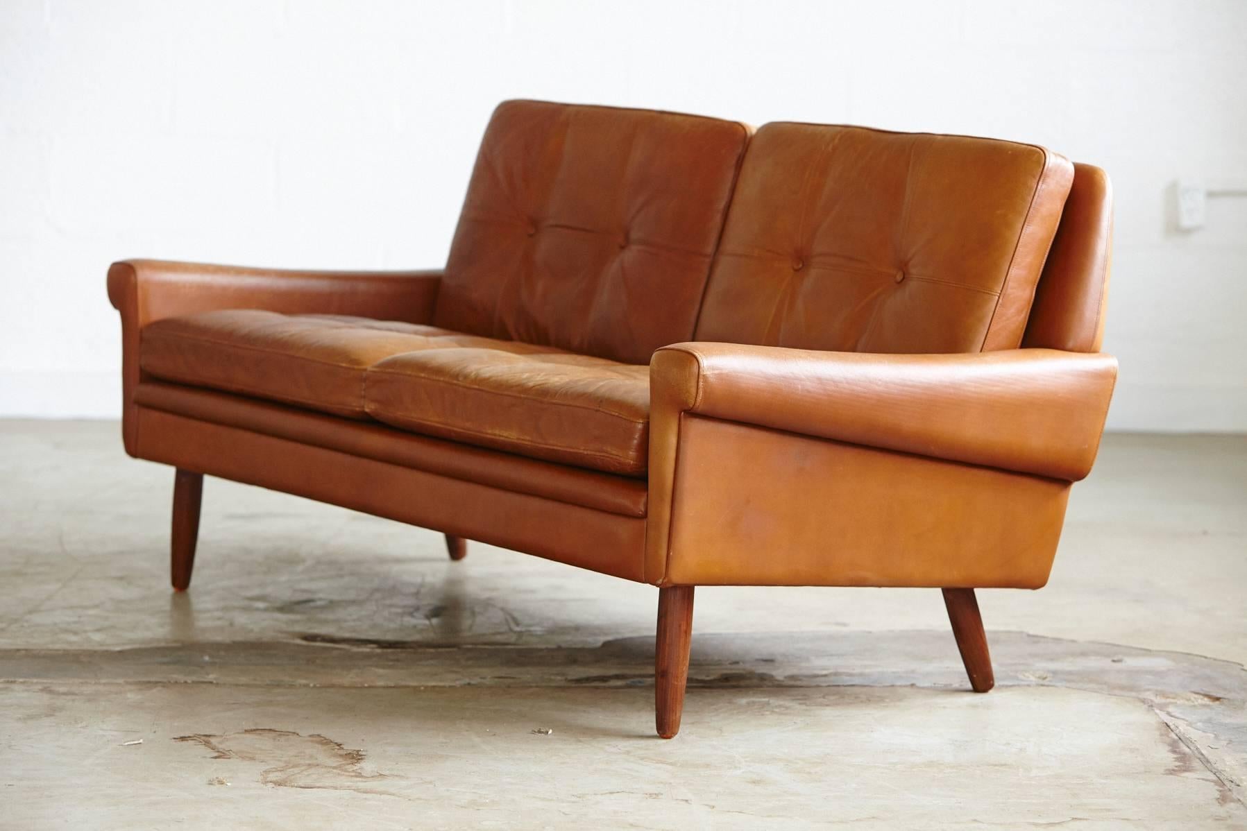 Stylish and charming tan leather sofa with great Mid-Century verve by acclaimed Danish designer, Svend Skipper. Beautiful lines, this sofa looks amazing from all angles including the back. High quality leather remaining soft and showing just the