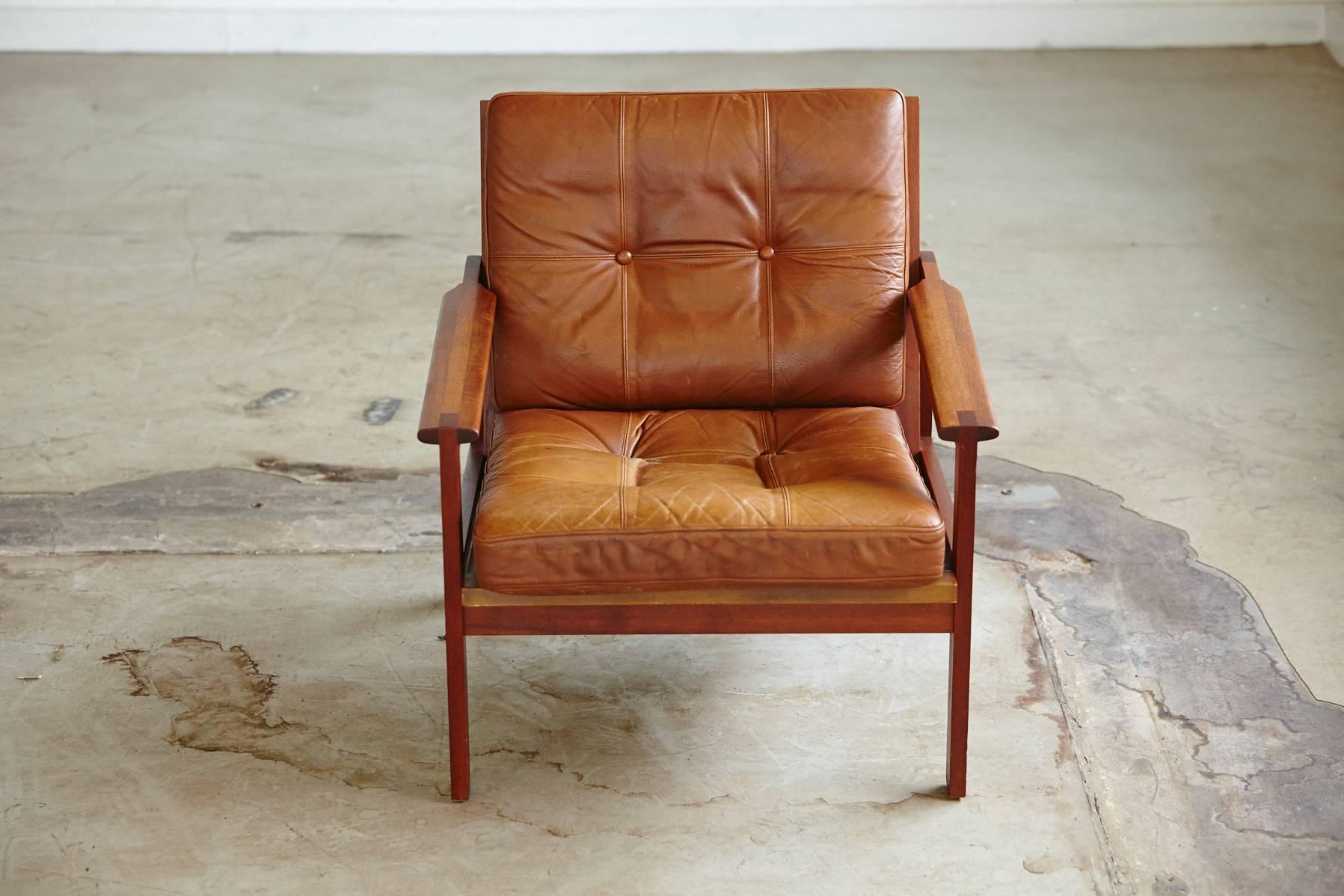 Leather armchair in teak from the Capella series designed in 1958 by Danish designer Illum Wikkelsø for N. Eilersen. 
Beautiful wood detailing on the armrests, loose leather cushions with a wonderful back structure.
The armchair comes in an