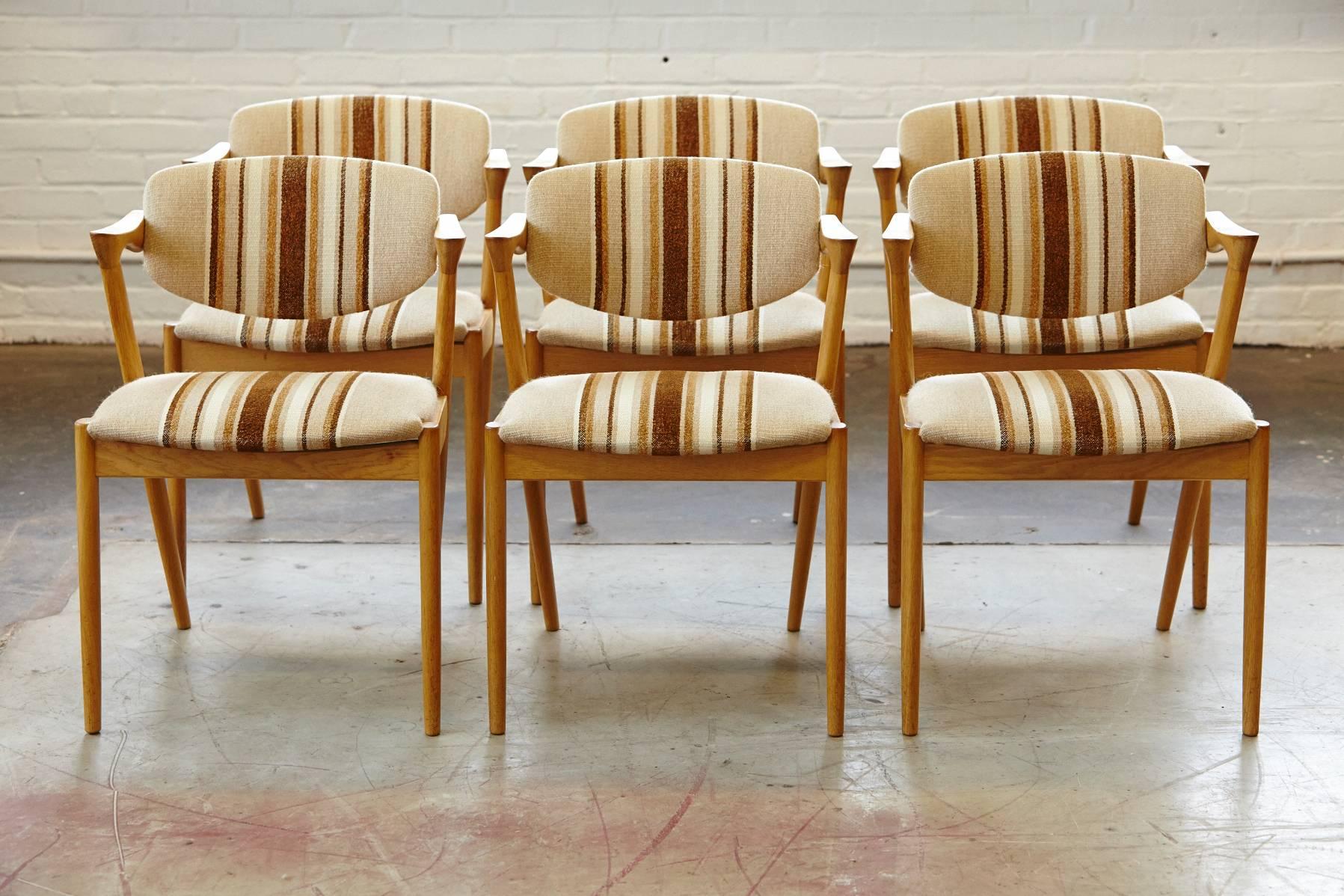 An iconic design featuring stunning angles and a tilting backrest. Retains its original cream and brown-striped fabric which makes a superb match with the rich oak color of the base. One of the most stylish chairs to come of the 1950s creating a