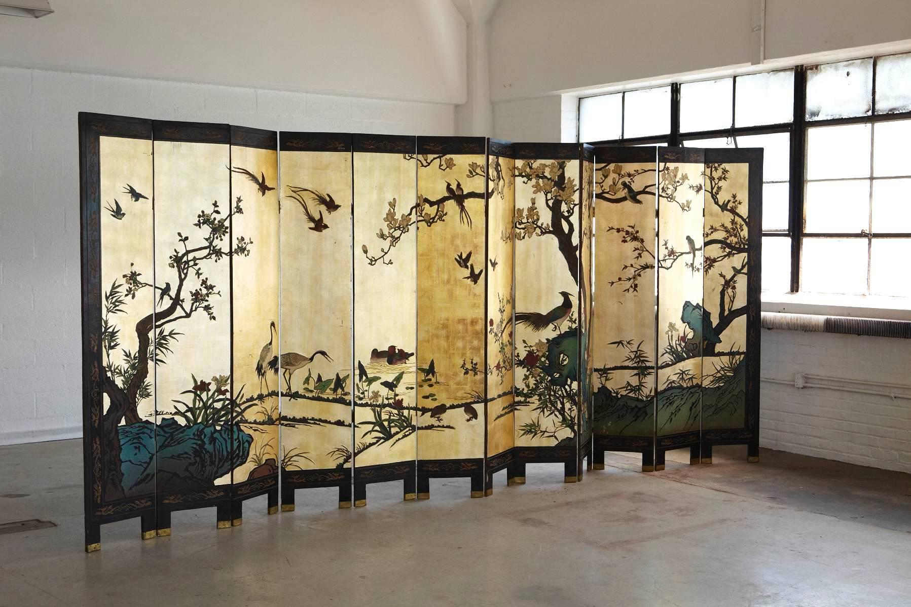 Impressive, large, 12-panel double sided hand-painted, hand-carved Coromandel screen. The gilded side is showing a detailed landscape with birds, the black side is showing a more minimalistic, puristic landscape with bamboos and mother-of-pearl
