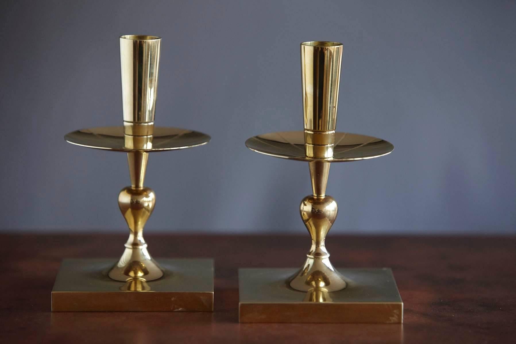 Elegant pair of Tommi Parzinger solid brass candleholders made by Dorlyn Silversmiths New York, manufacturers hallmark engraved on the bottom.