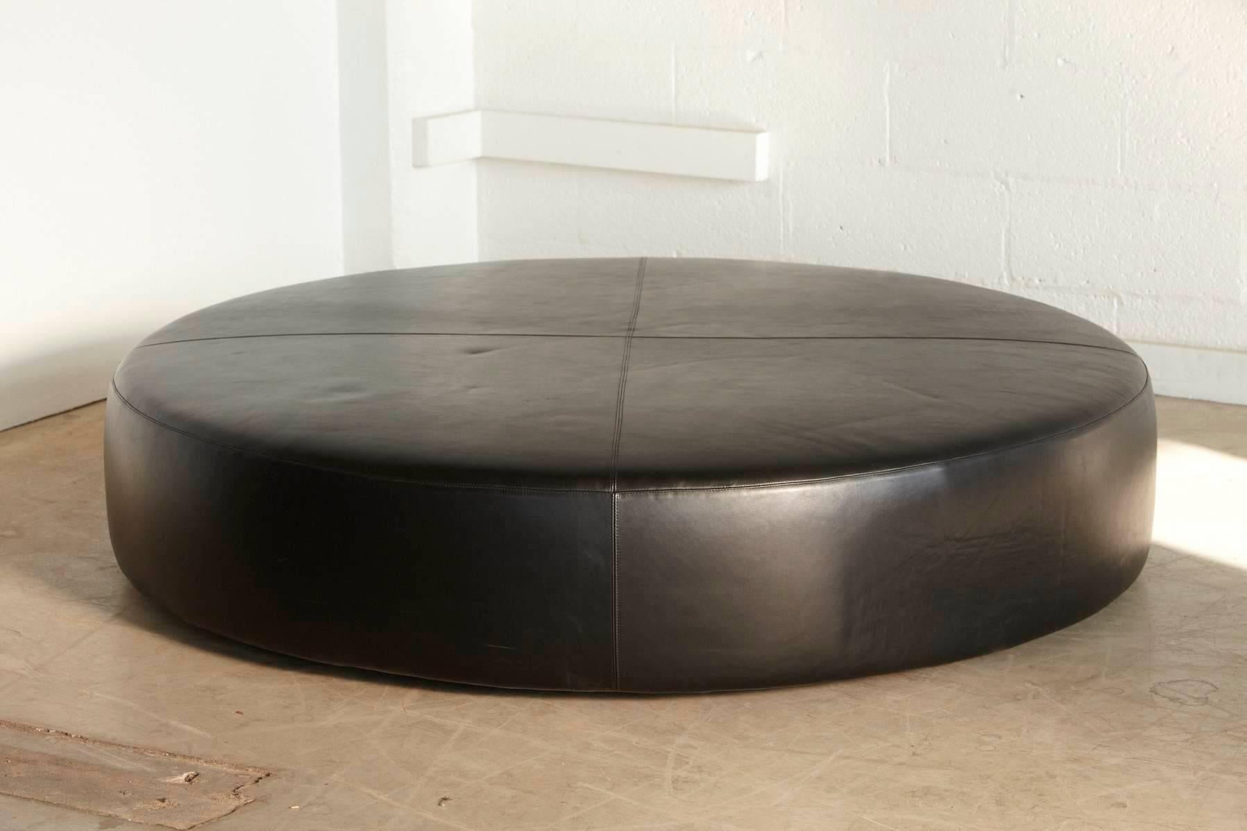 The large round leather ottoman can be used almost everywhere, for example as a useful table conveniently next to a sofa, a seat or a stand alone object and is the perfect neutral match for many differently styles of sofas. The ottoman has seams on
