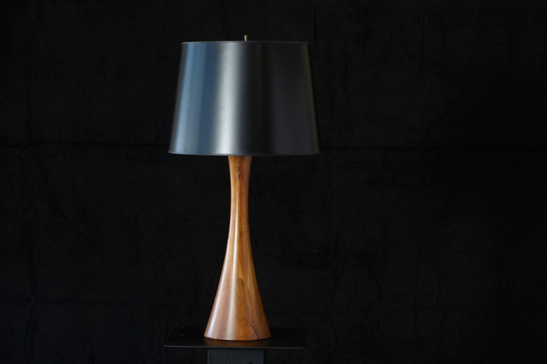 Beautiful sculpted concave teak table lamp with new black shade and silver lining.
Height to finial 35.5 inches.
The lamp can be sold without the shade, with a price reduction of $75.
 