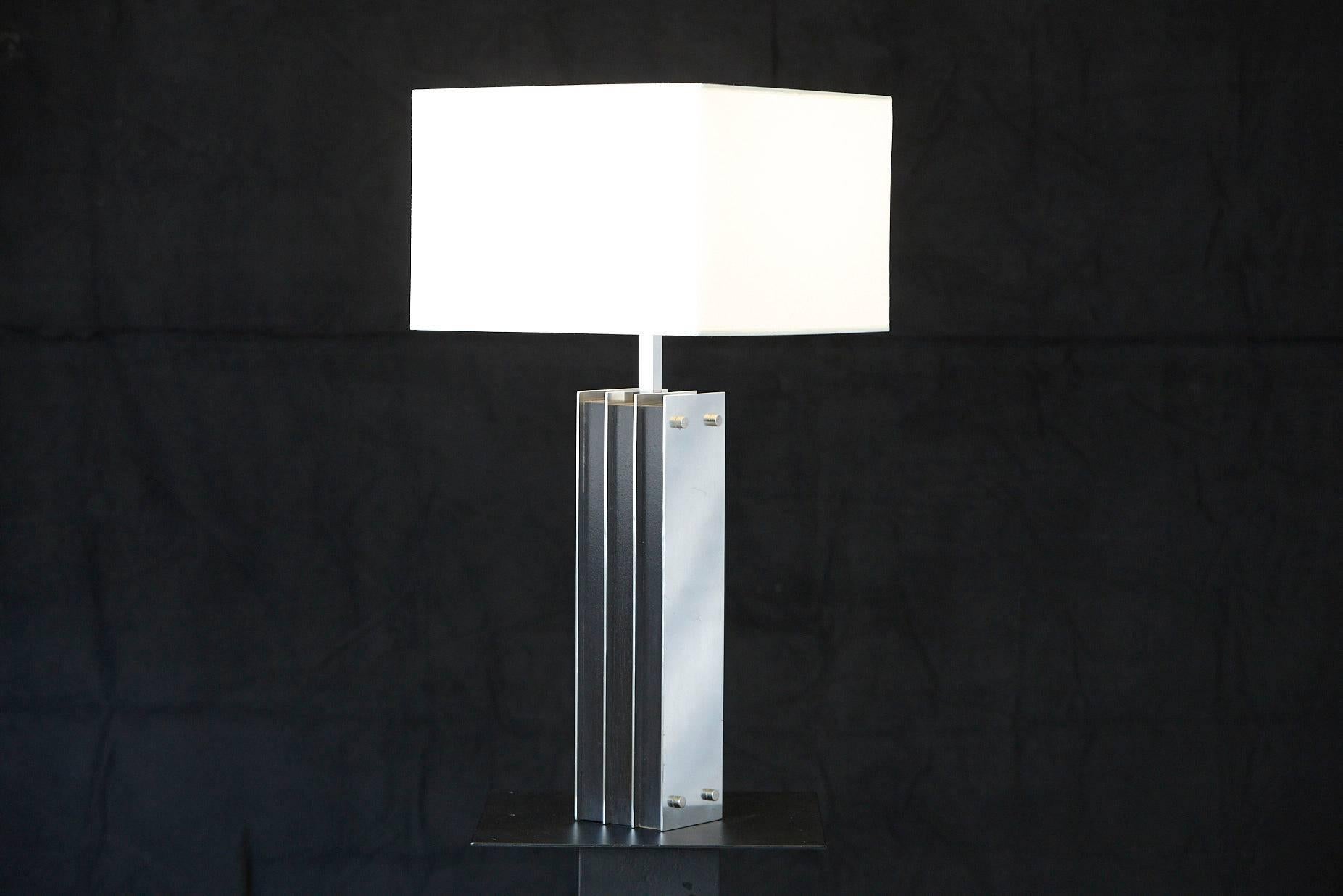 Tall table lamp with polished aluminum elements alternating with black veneered wooden elements.
Good condition with a few slight scratches in the aluminum, please refer to the photos.
Height to finial 33.75 in.
Can be sold without shade, with a