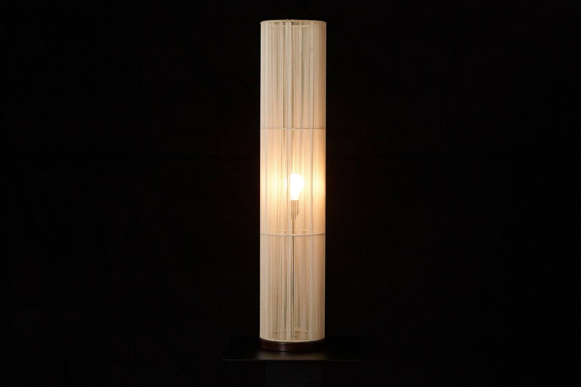 Very atmospheric and puristic cylindrical string wrapped floor lamp from the 1970s on a wood base.