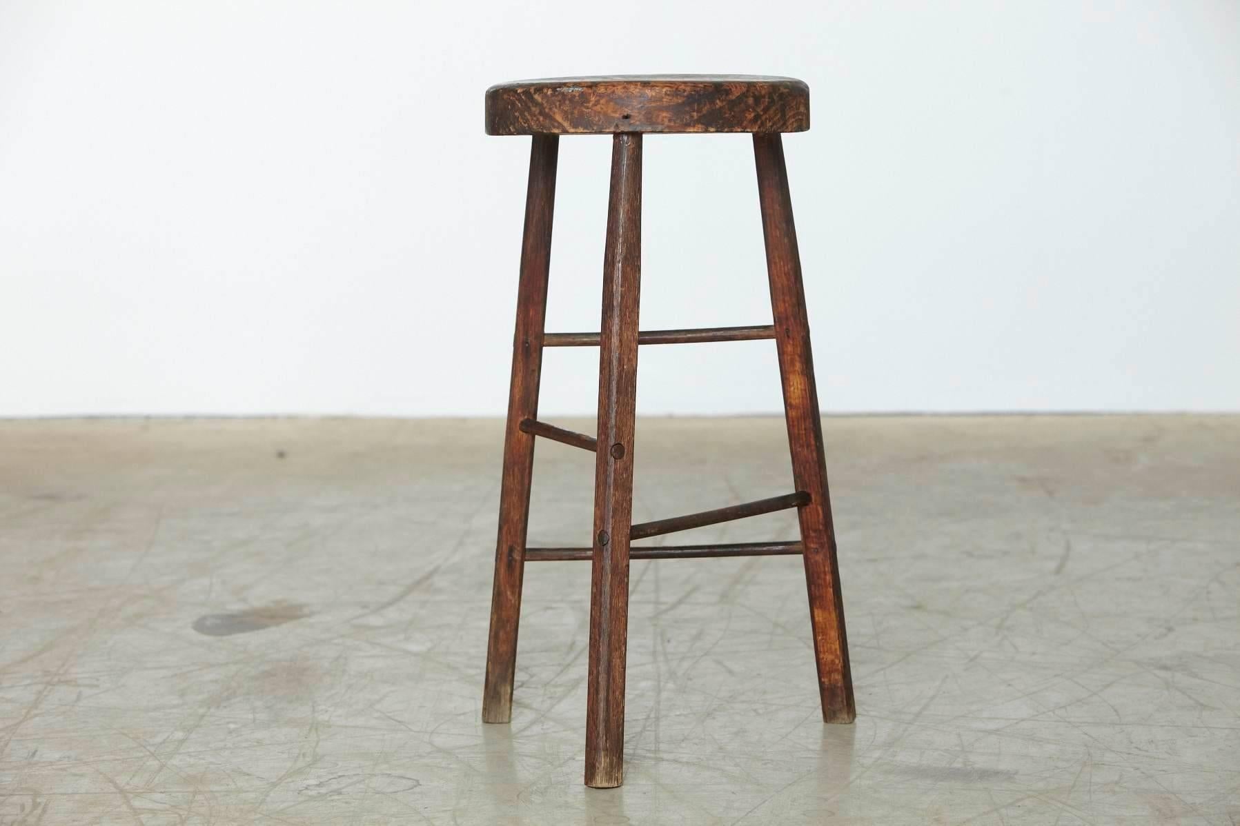 Minimalist rustic three legged wooden stool with thick top.