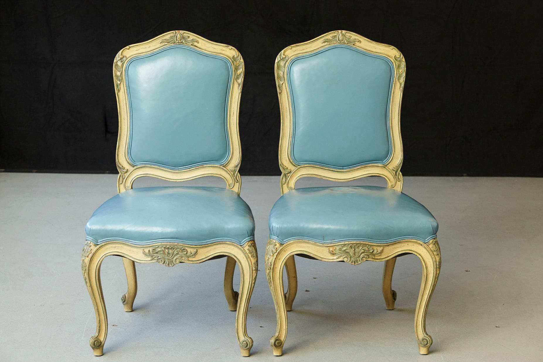 Exceptional pair of French Louis XV style side chairs with antiqued blue and white finish, on frames and cabriole legs with carved knee mounts.
Custom Upholstered in powder blue leather seat and back.
Light scratch in the leather on and chair,