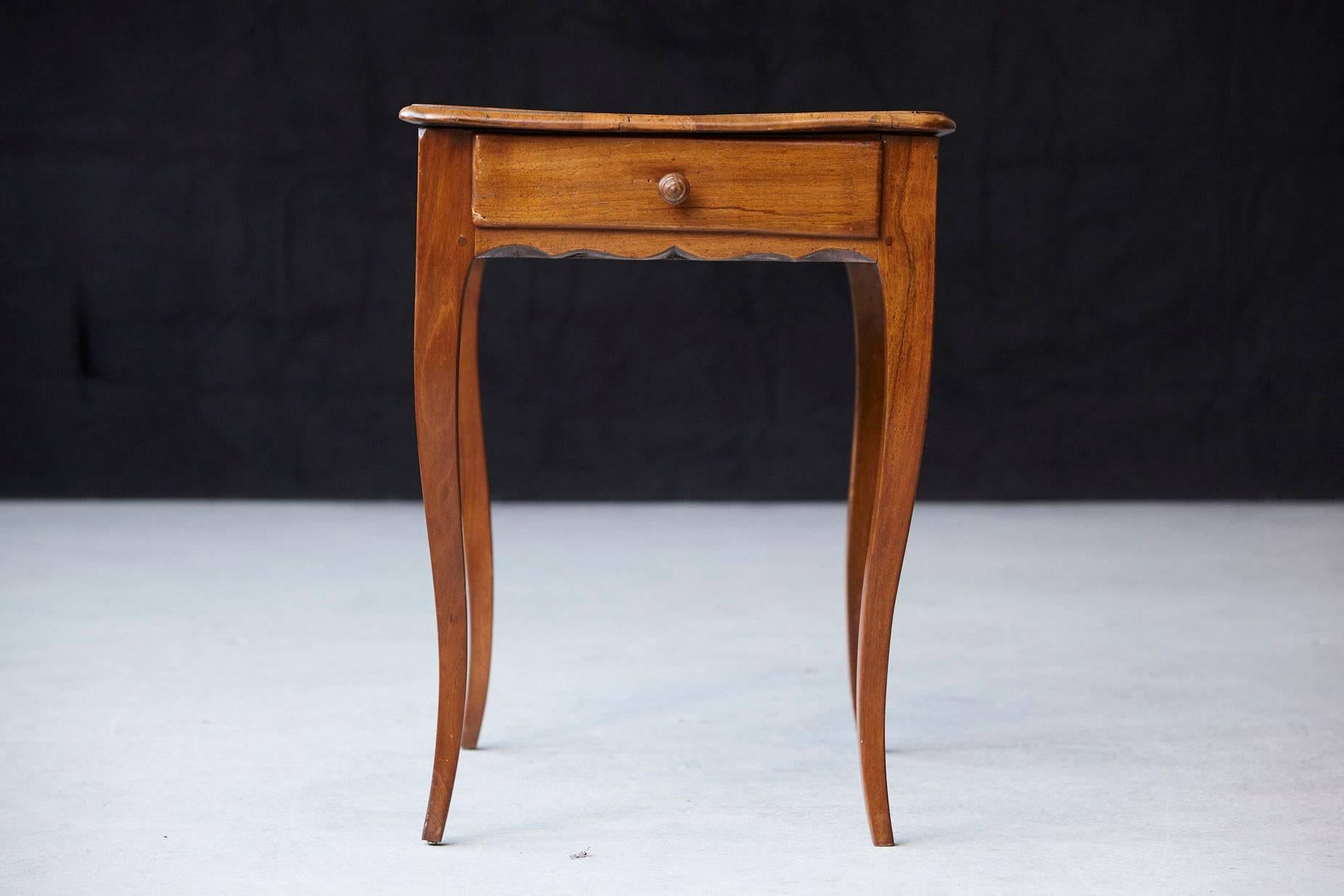 Charming late 19th century, circa 1890s, occasional table in walnut, featuring single frieze drawer, a shaped apron raised on cabriole legs.