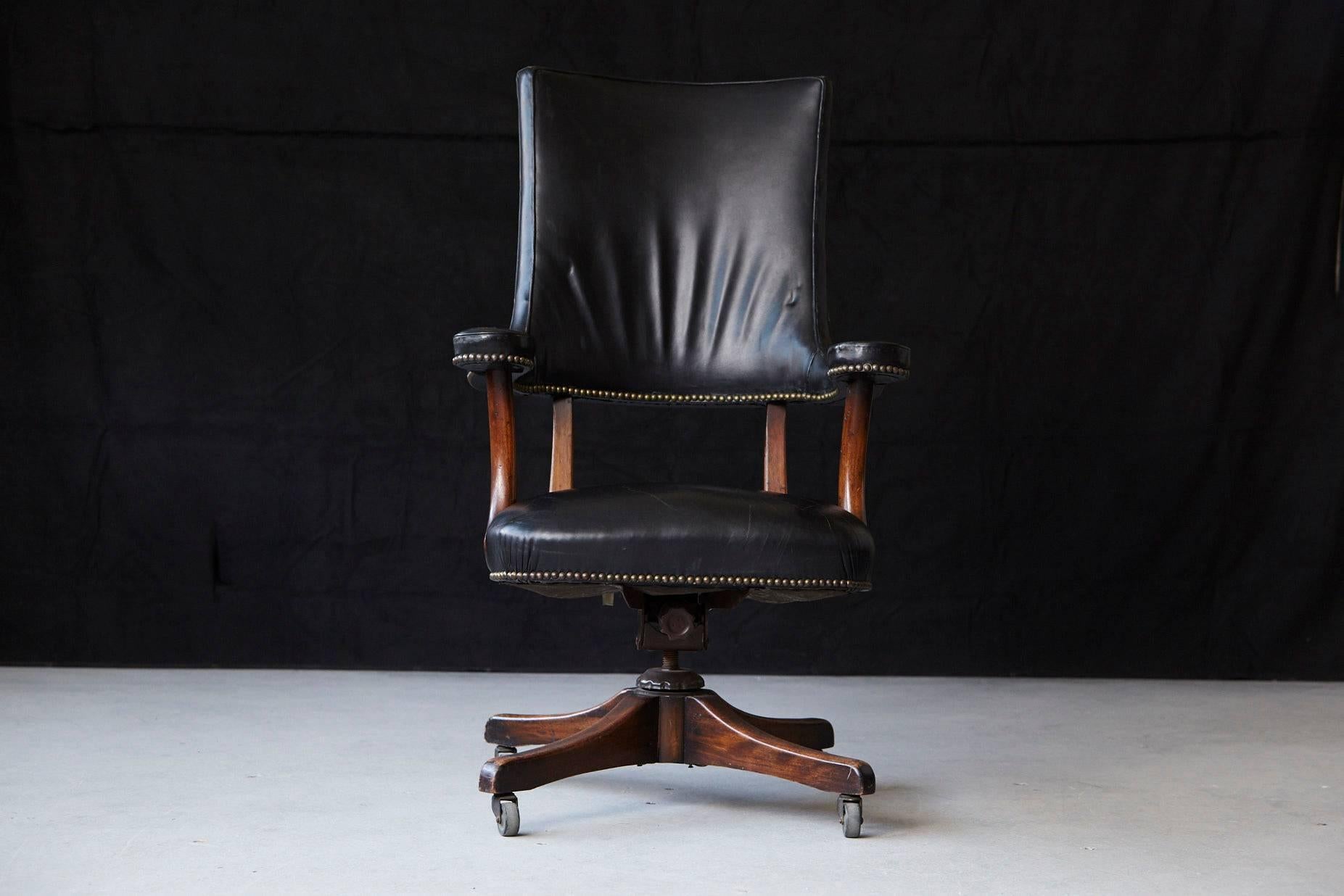 Yale Berge high quality early 1970s reproduction high back 'banker's chair on castored swivel base. Walnut frame covered in brass nail trimmed thick black leather.
There is a minor, professionally exercised repair on of the armrests. Please refer to