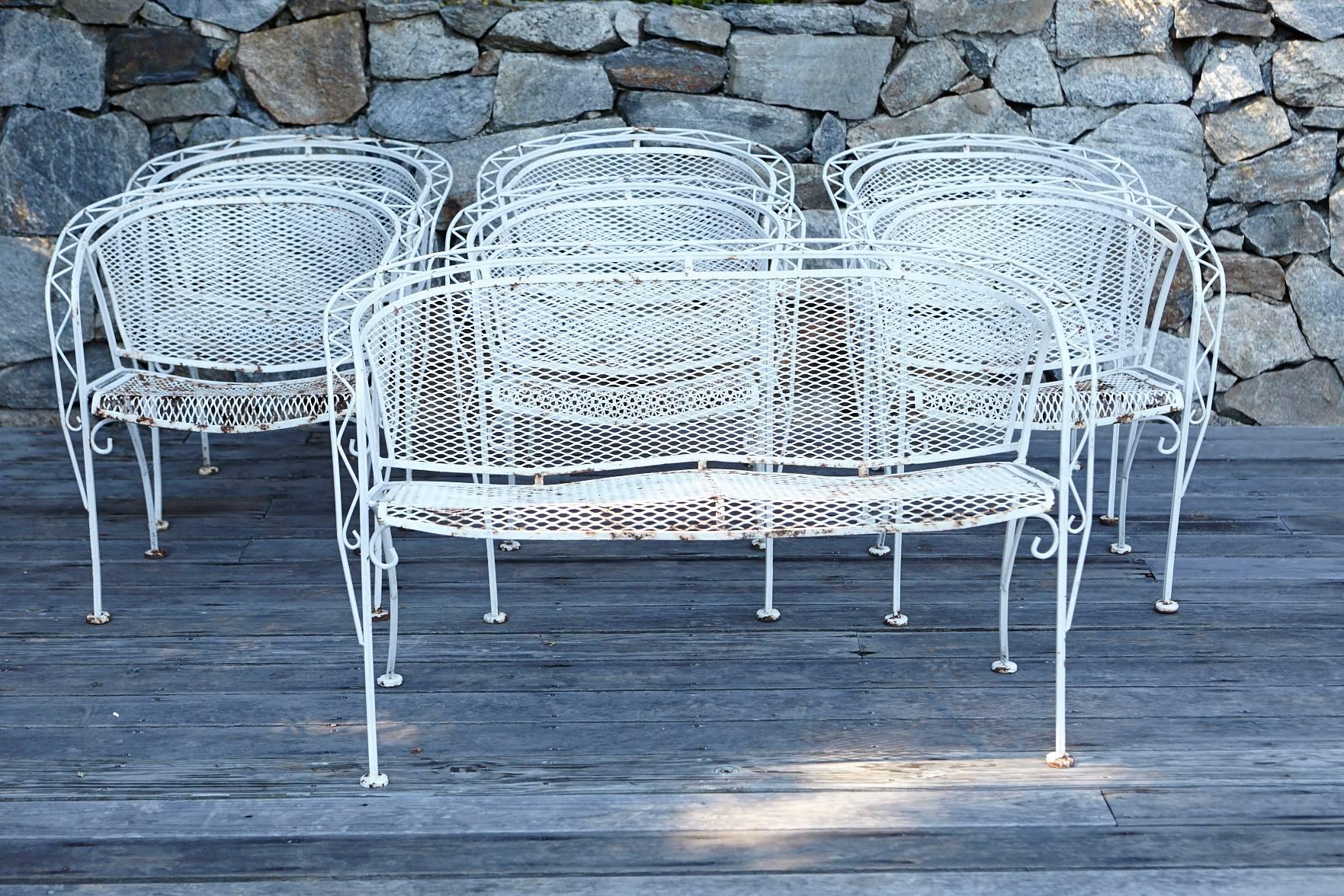 Complete Mid-Century Modern iron patio set with sculpted frame, barrel back rests and angled legs. Six chairs, one large out door dining table and a loveseat.
The set is in good sturdy condition, structurally sound, no breaks, welds or repairs. The