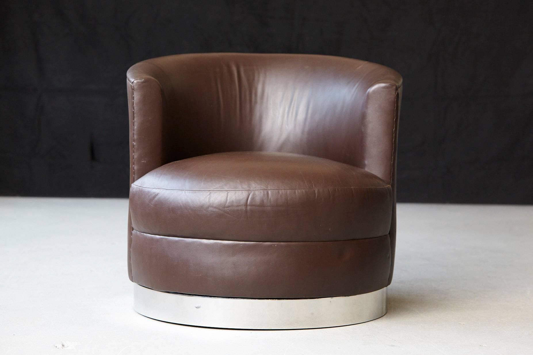 Chocolate brown leather swivel club chair on a circular chromed steel base in the style of Karl Springer.
The chair has a few scratches and pressure marks, please refer to the detailed photos.
 