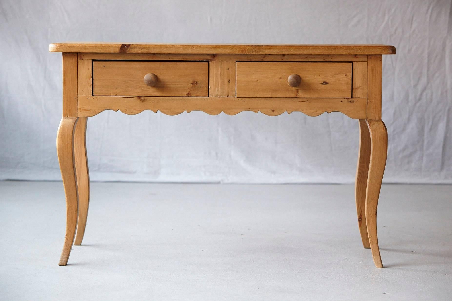 English Country style console in natural pine, with two drawers, shaped apron and raised on cabriole legs.
Made in England stamp under drawer.