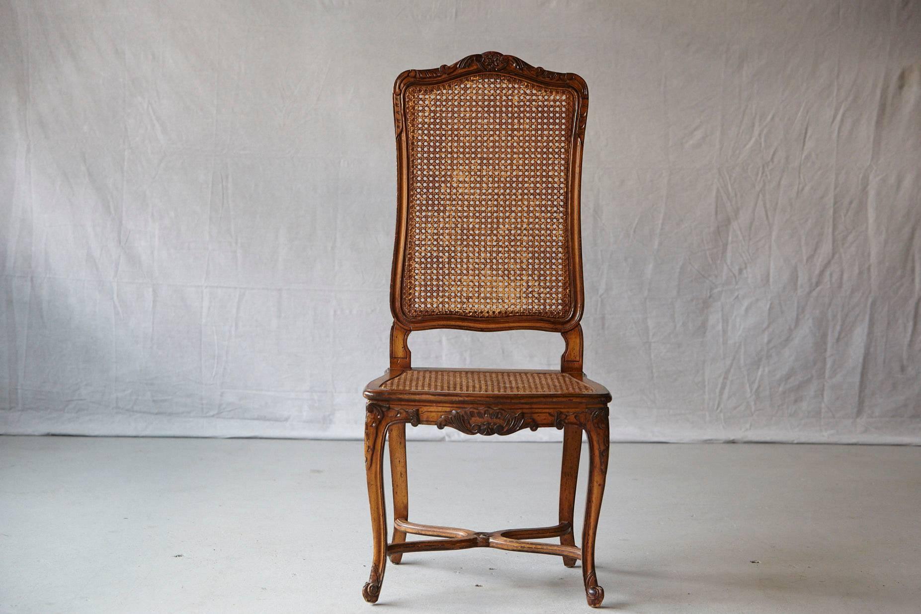Lovely 19th century walnut high back chaise with caned back and seat. Carved knee mounts and blossom cresting, raised on cabriole legs. Legs joint by intersecting stretcher.
The cane is in very good condition, some flaking to caning finish.
