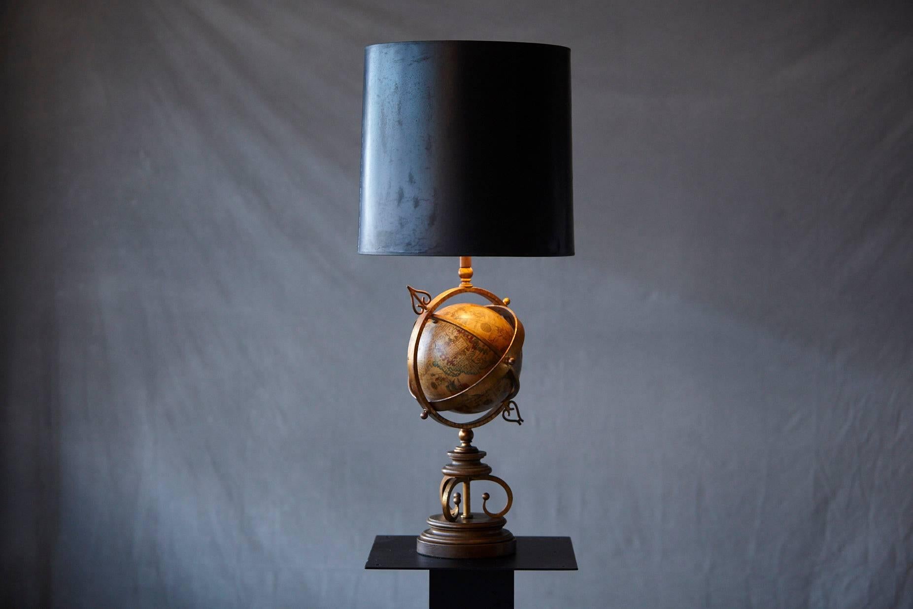 Exceptional brass armillary table lamp with a rotating terrestrial glass globe on a wood base, circa 1940s.
The glass globe is in excellent condition, the crackling black shade has it's wabi sabi charme........!
Dimensions: Diameter base 7.5 in;