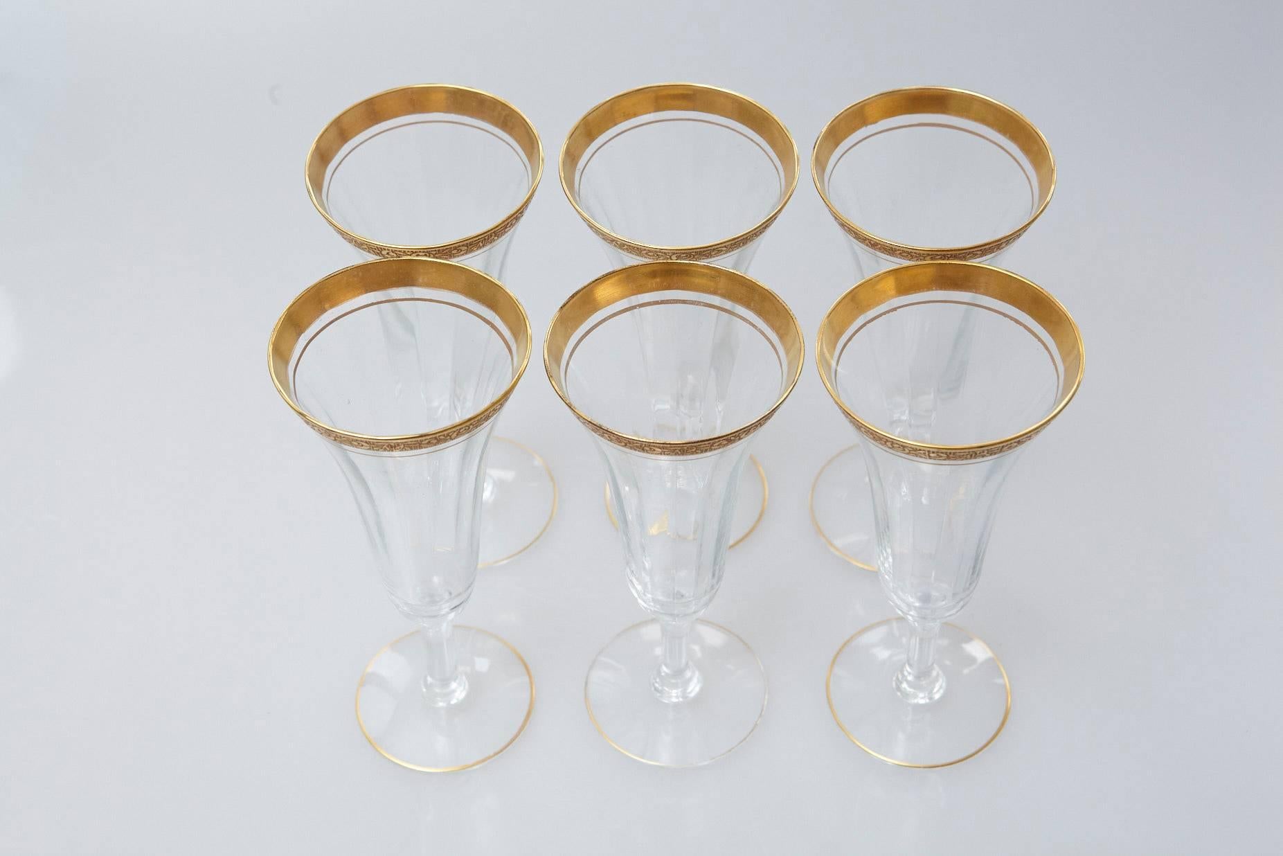 Early 20th century set of six champagne flutes featuring an etched floral gilt design around the rim and a stripe of gold around the base.
Good vintage condition, no chips to the rim or base.