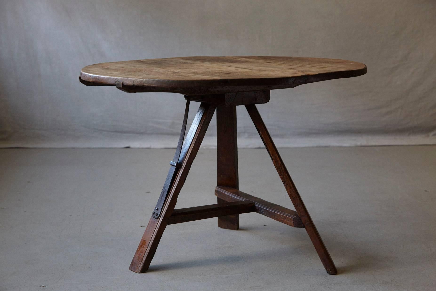 Charming 19th century circular three legged tilt top wine tasting or centre pine table. The tabletop has a nice graining,
the three legged base is sturdy and is equipped with a beautiful wrought iron latch to hold the top in place.
The table can